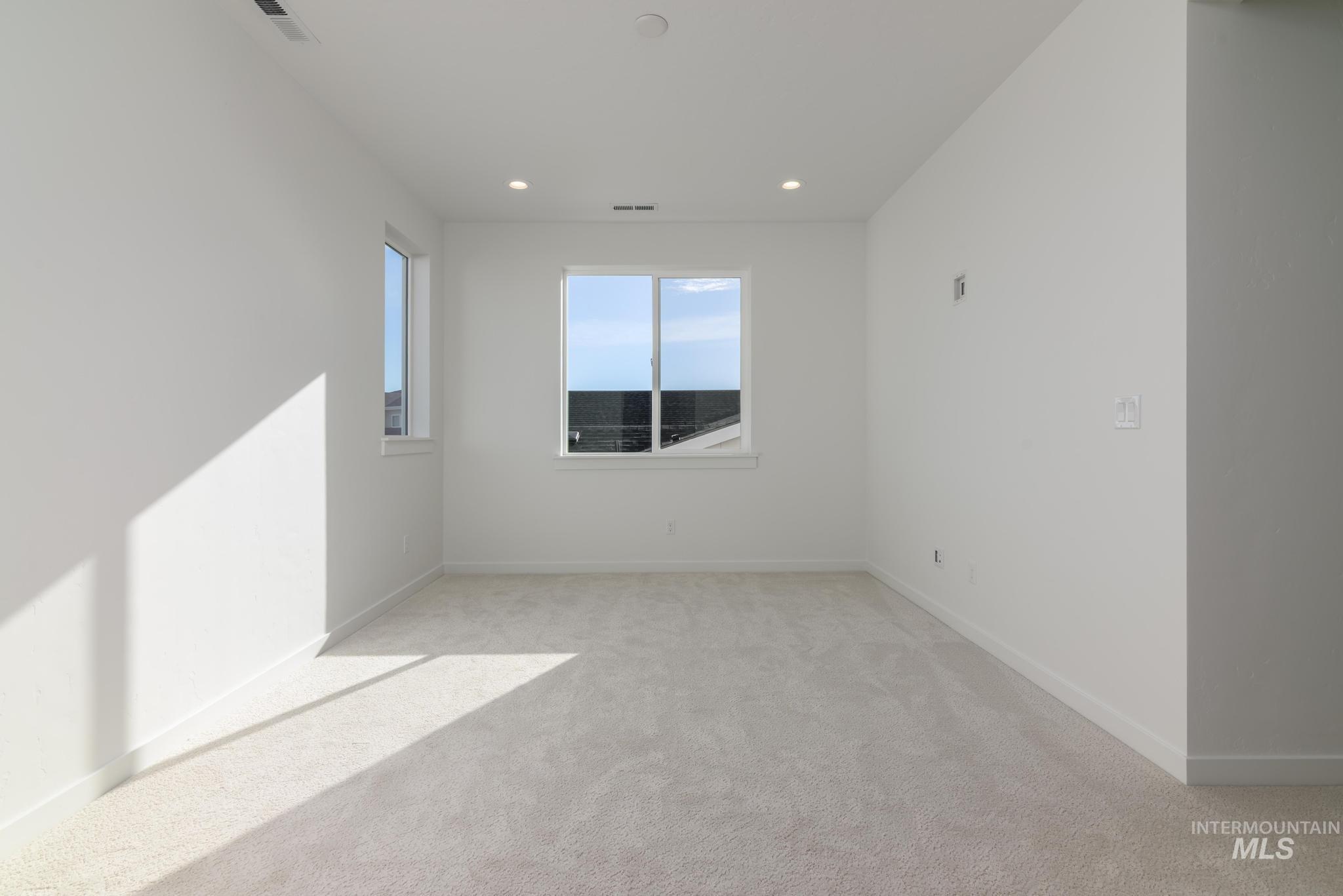 Empty room featuring light colored carpet and recessed lighting