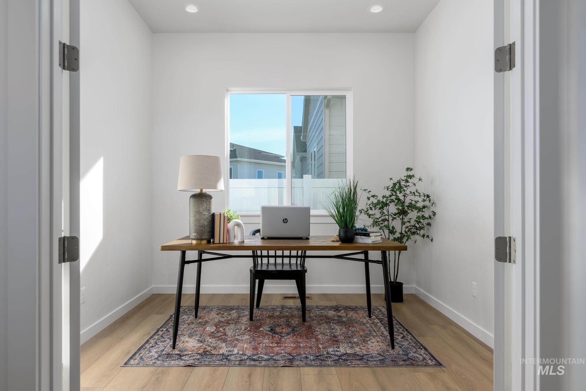 Home office with light wood-type flooring and recessed lighting
