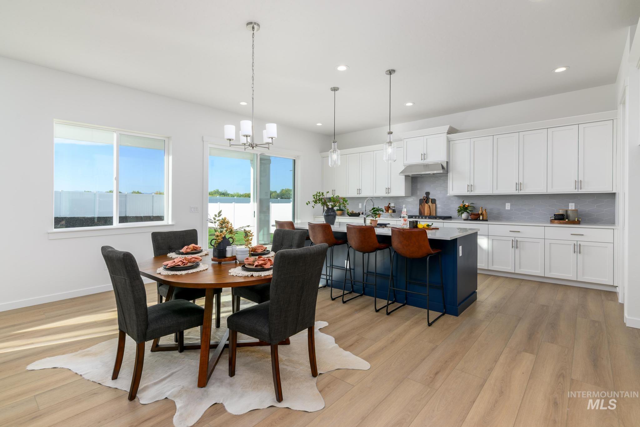 Dining area with light wood-style floors, a chandelier, and recessed lighting