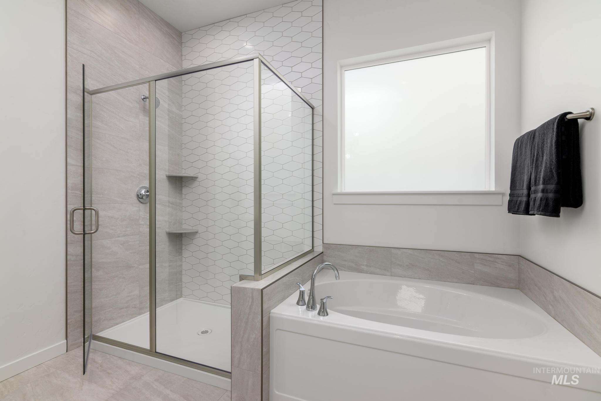 Full bath featuring a bath, a stall shower, and tile patterned flooring