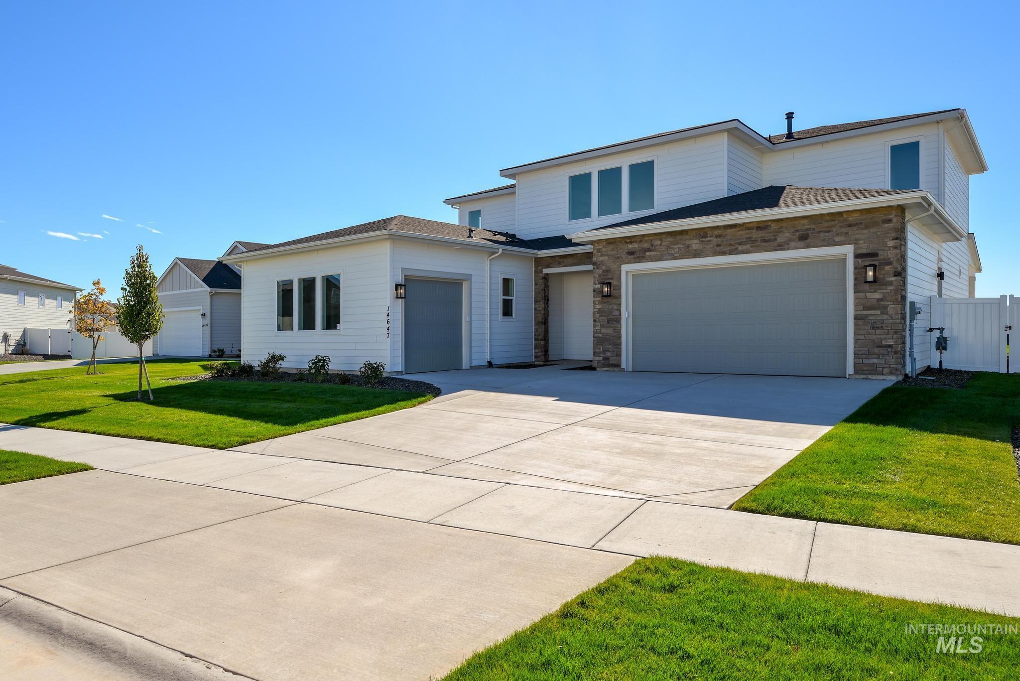 View of front of house featuring concrete driveway, roof with shingles, and a garage
