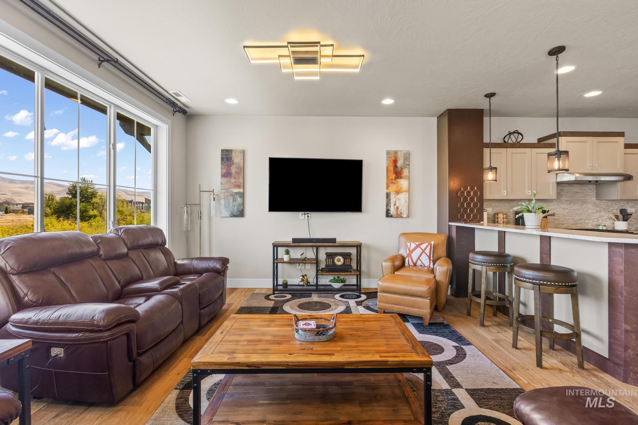 Living area with light wood finished floors and recessed lighting
