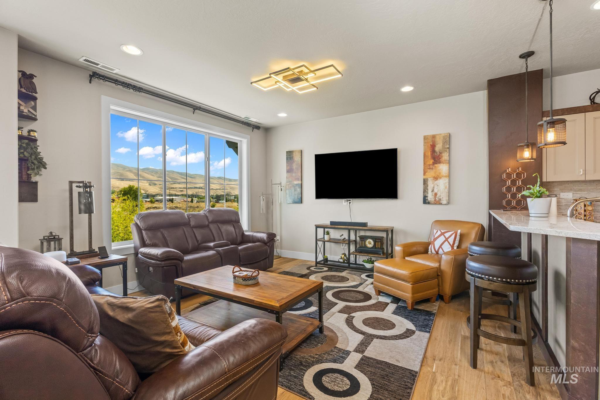 Living room with light wood-type flooring and recessed lighting
