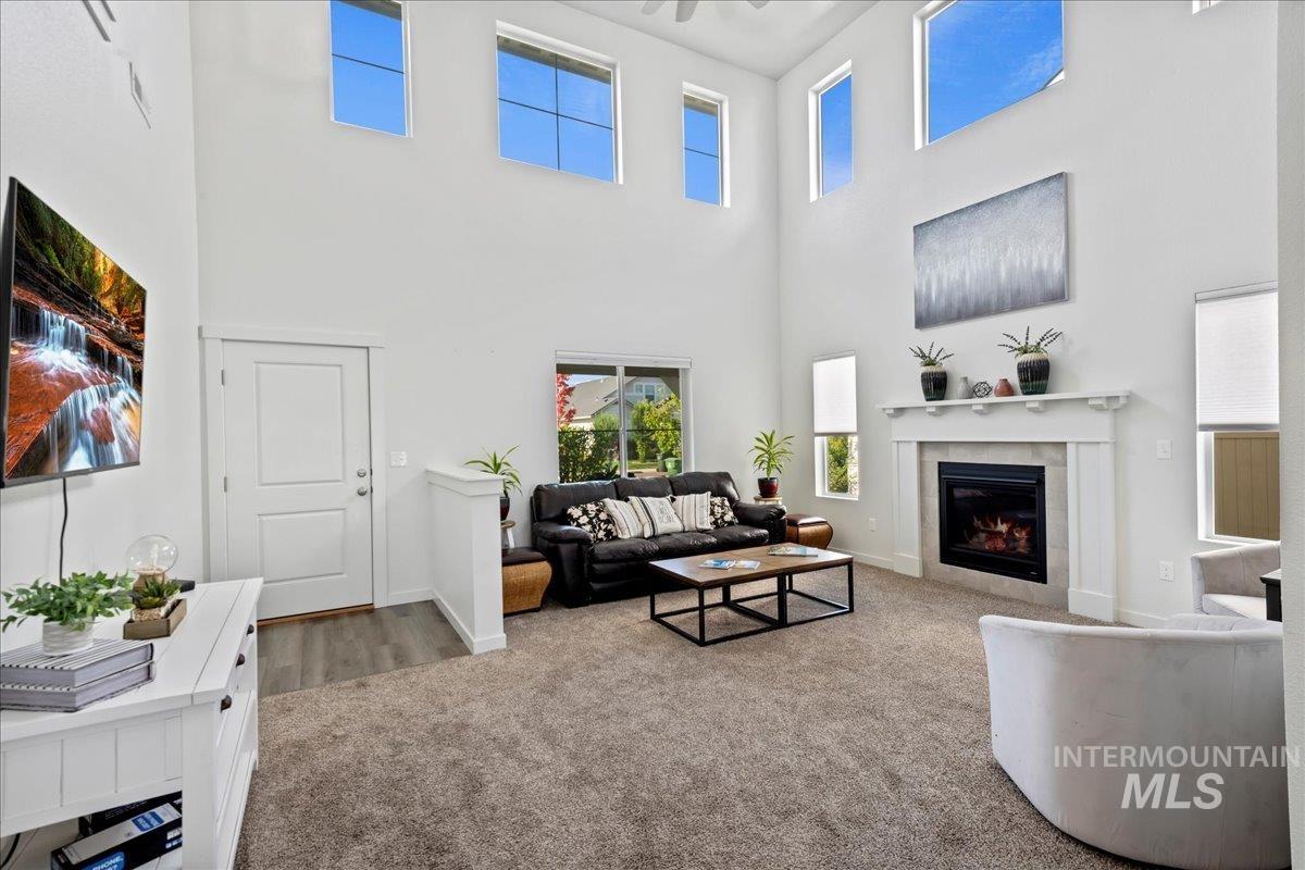 Carpeted living room featuring a fireplace and baseboards