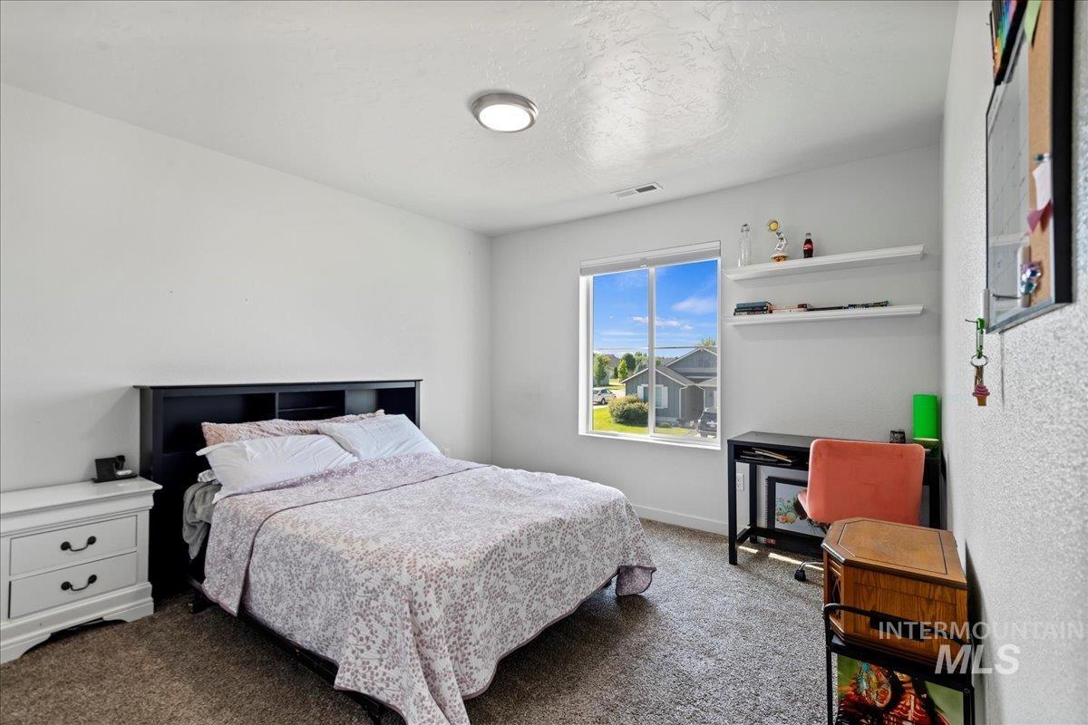 Bedroom featuring carpet flooring and a textured ceiling