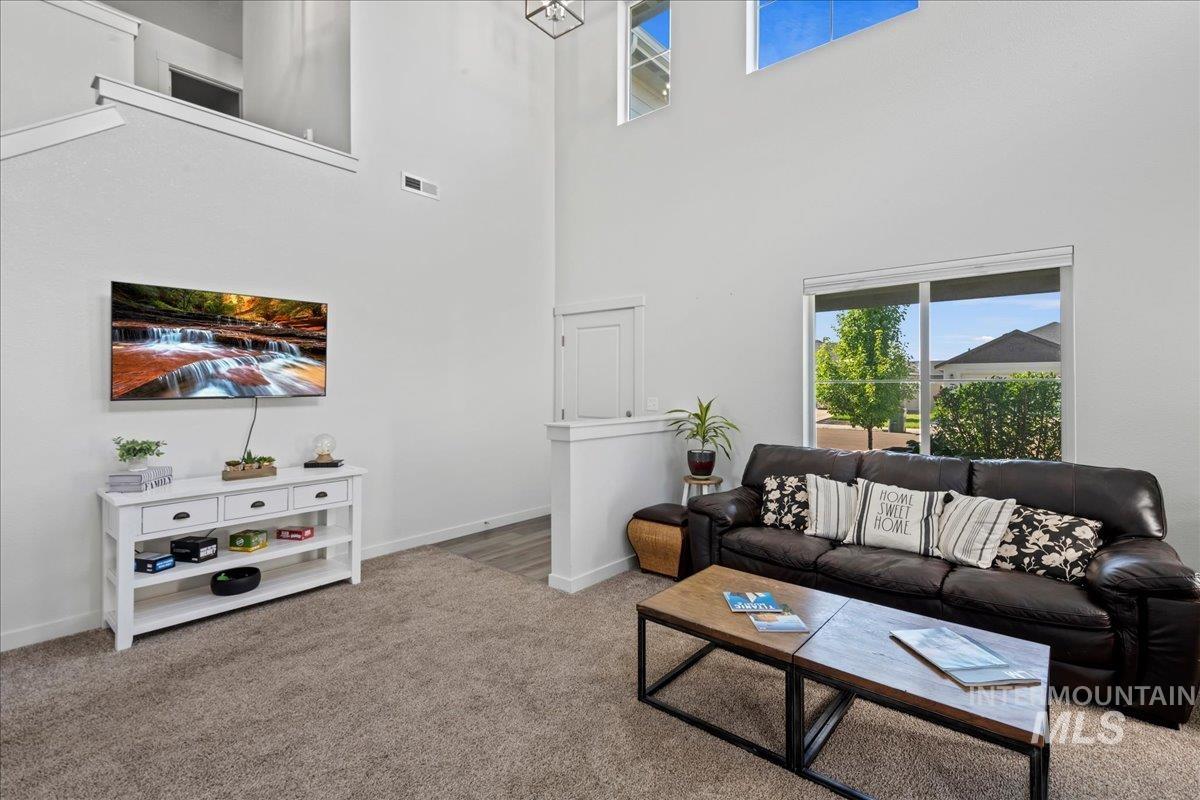 Living area featuring carpet and a high ceiling