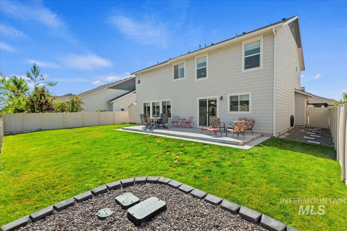 Rear view of house featuring a fenced backyard and a patio