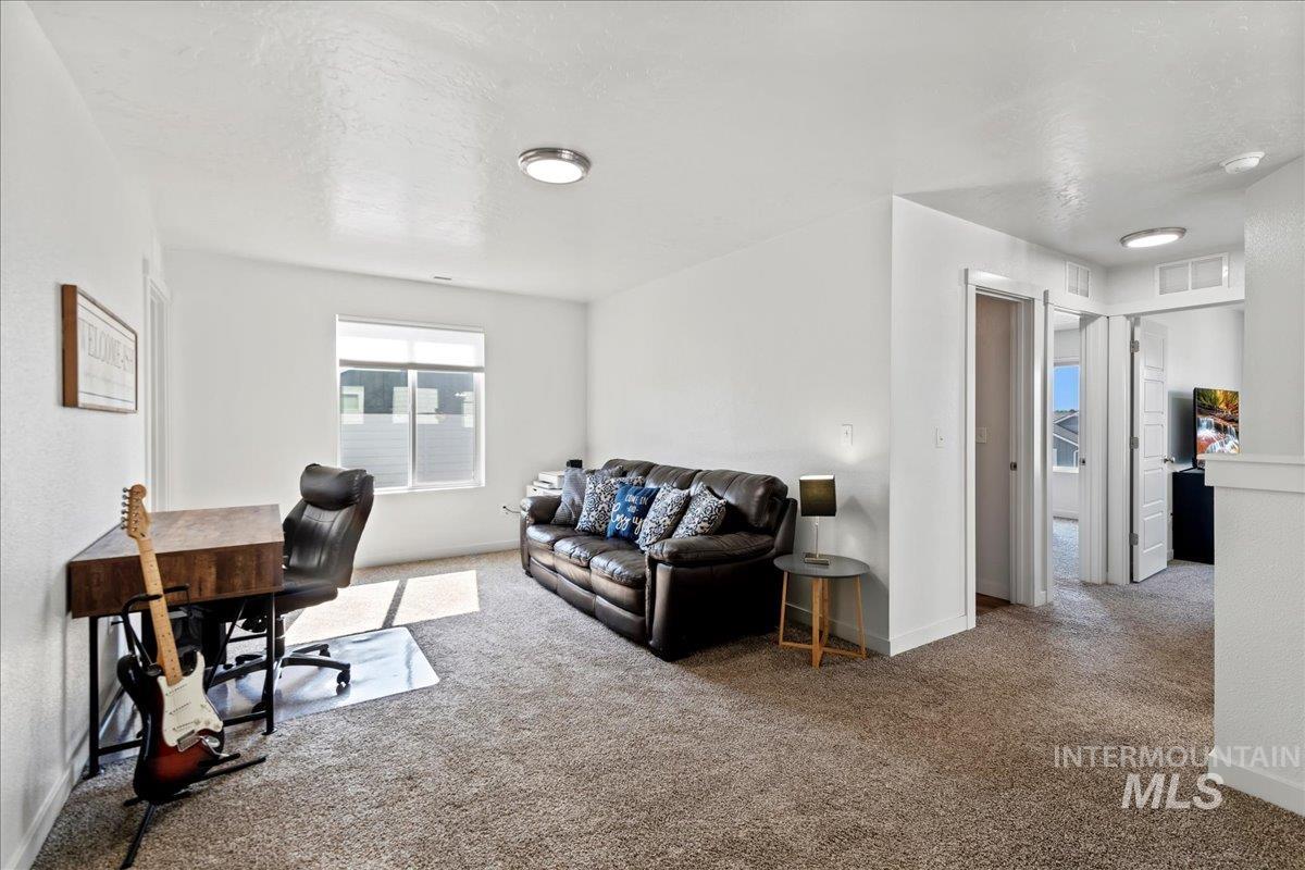 Office area featuring carpet and a textured ceiling