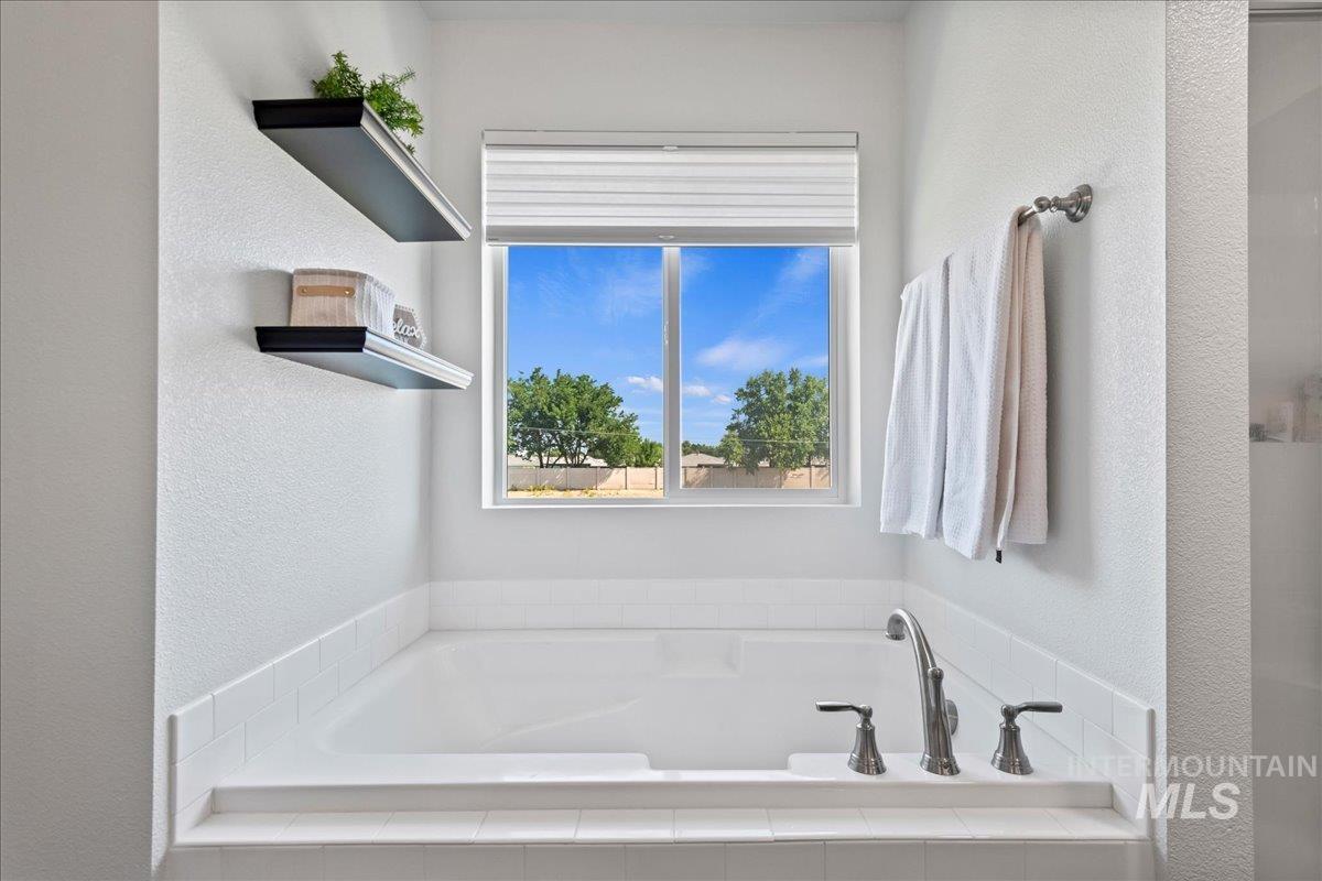 Bathroom featuring a bath and a textured wall