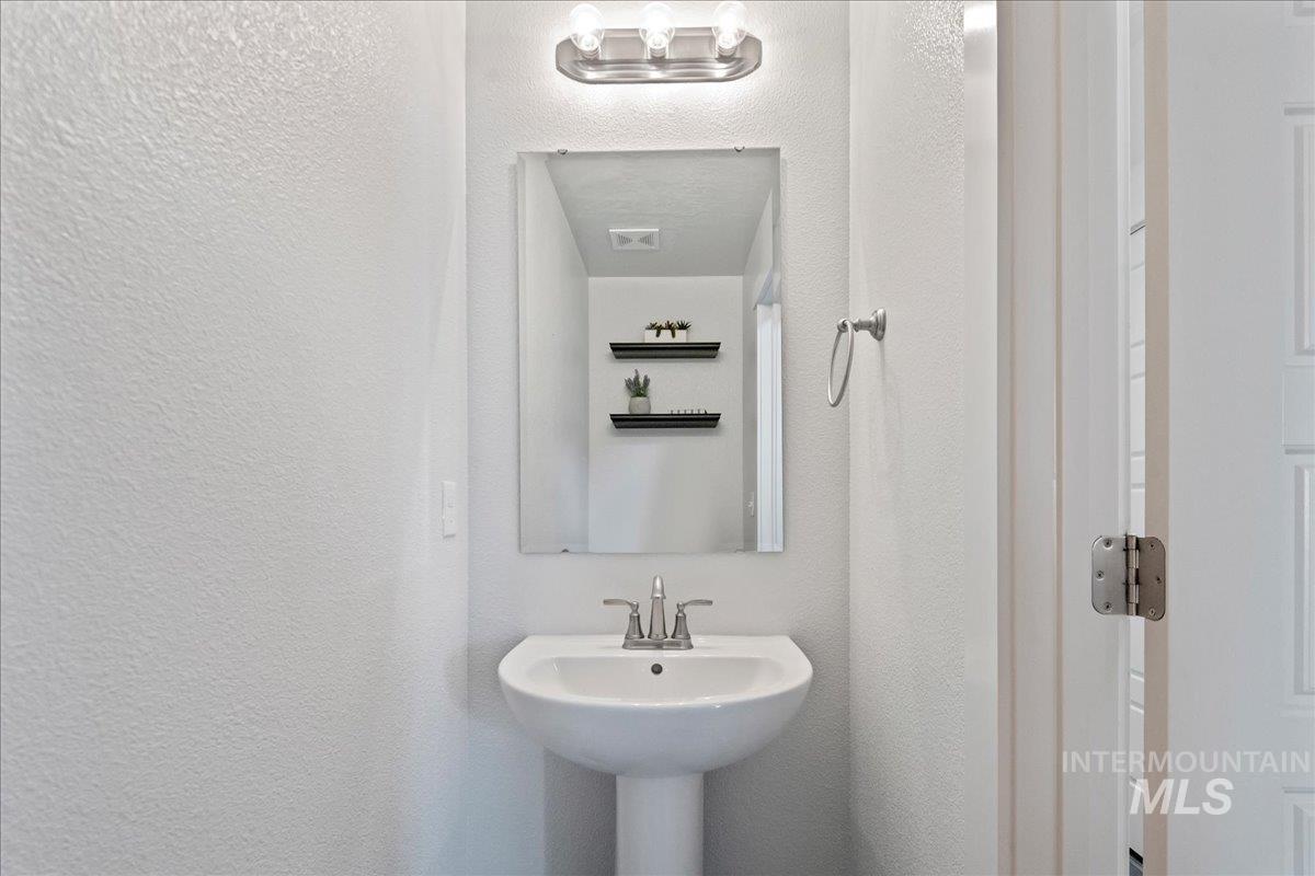 Bathroom featuring a textured wall and a sink