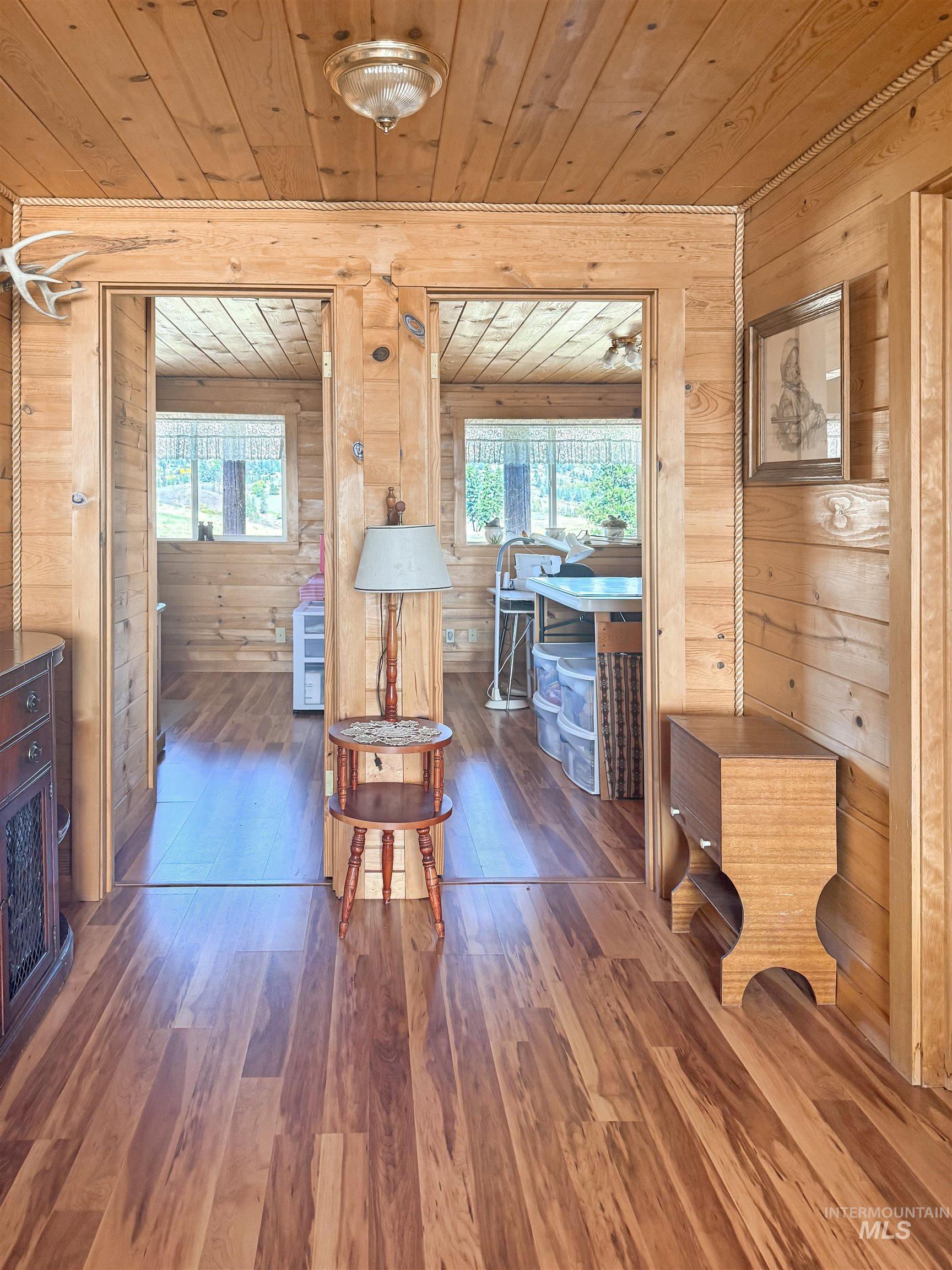 Dining space featuring wood finished floors, wooden ceiling, plenty of natural light, and wooden walls