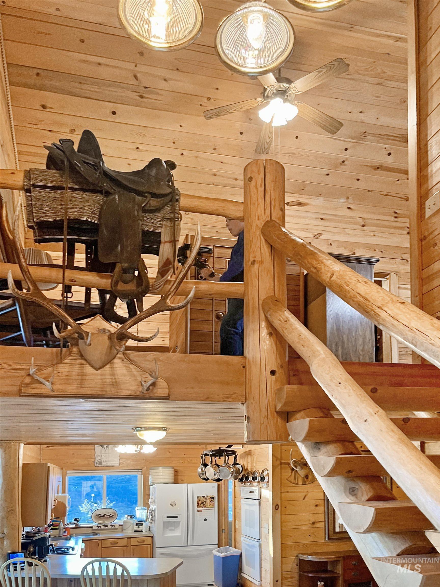 Stairway with wood walls, a towering ceiling, and wooden ceiling