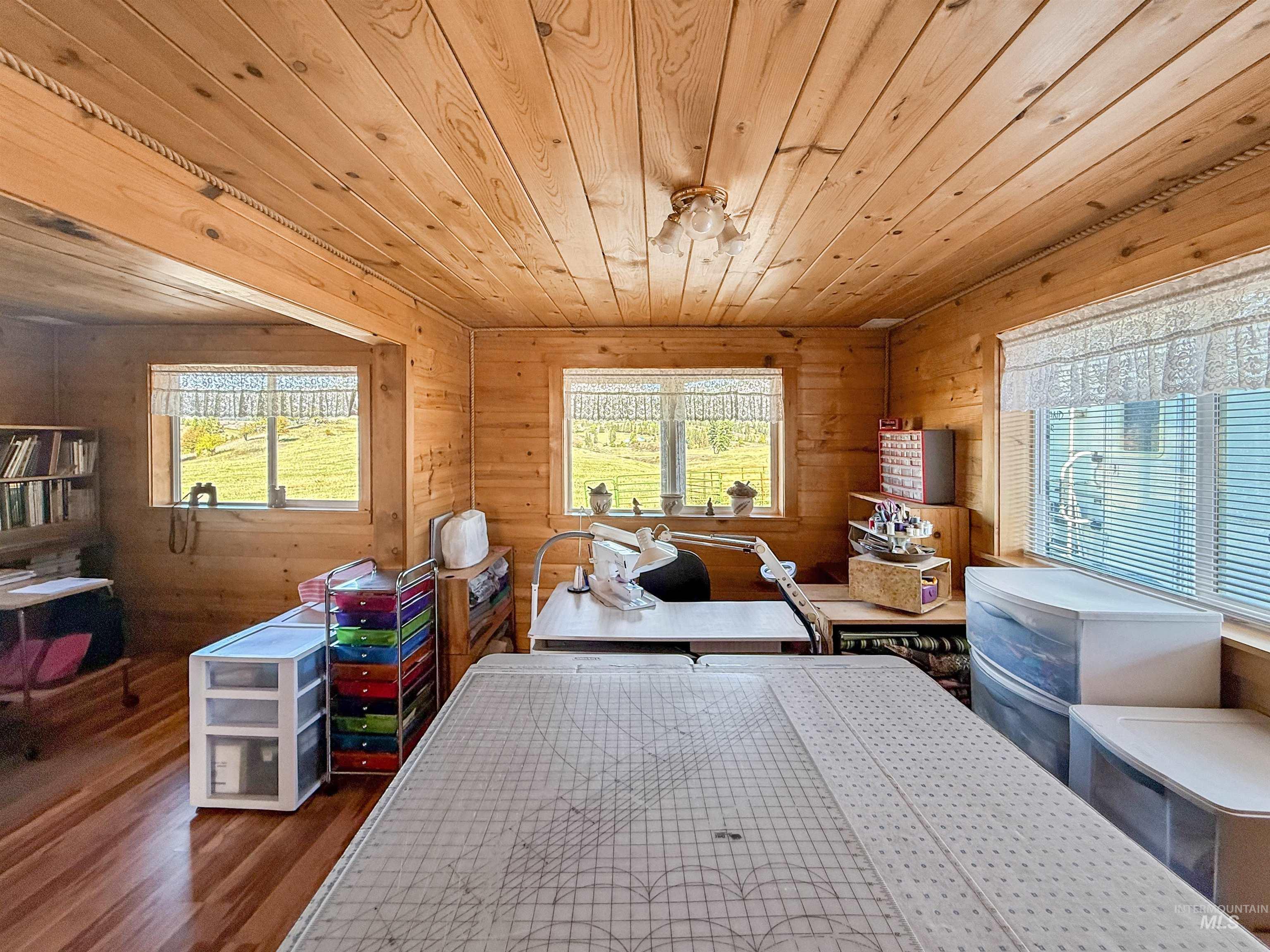 Bedroom featuring wood walls, wood finished floors, and wooden ceiling