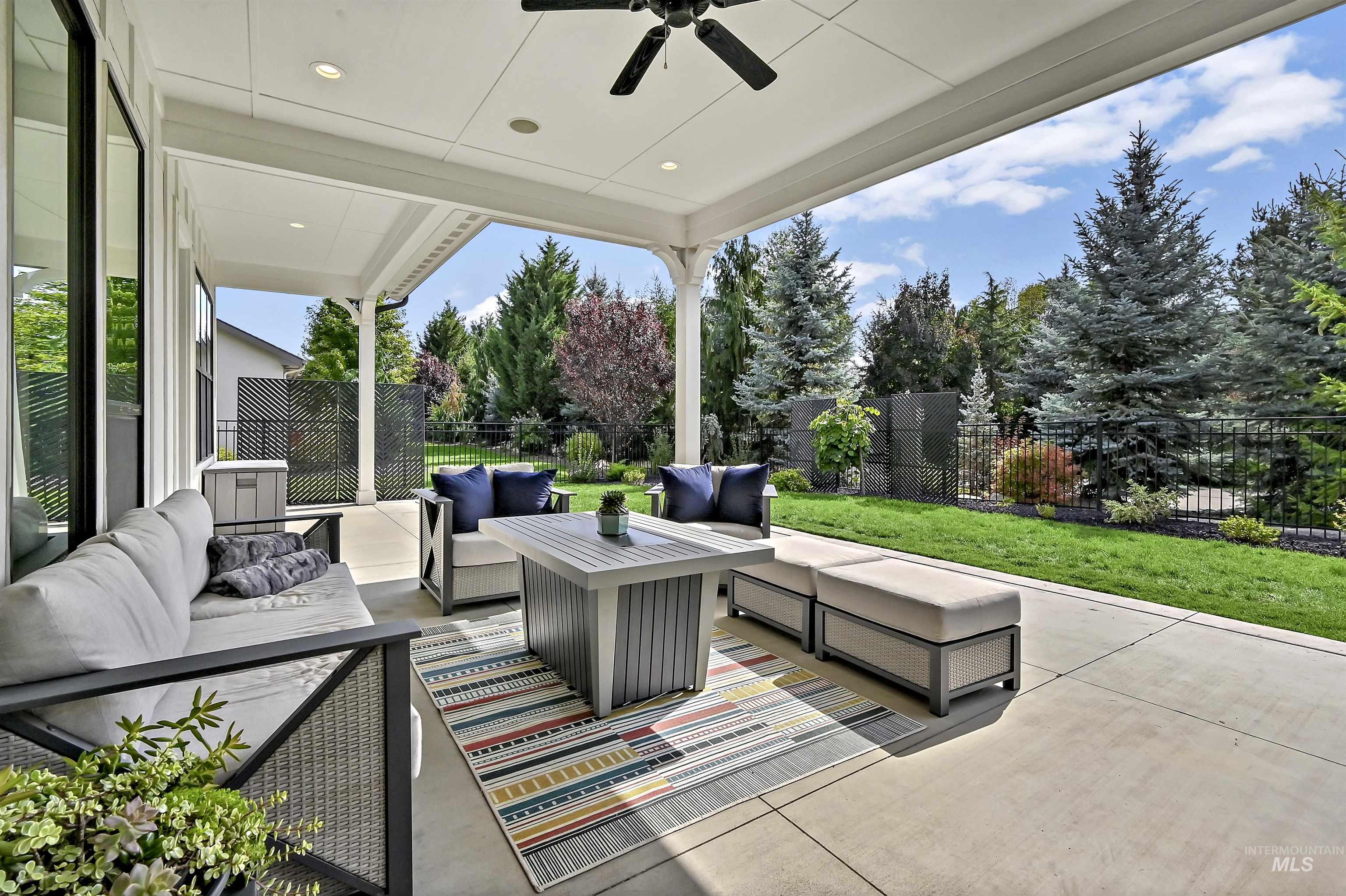 Fenced backyard featuring an outdoor hangout area, a ceiling fan, and a patio