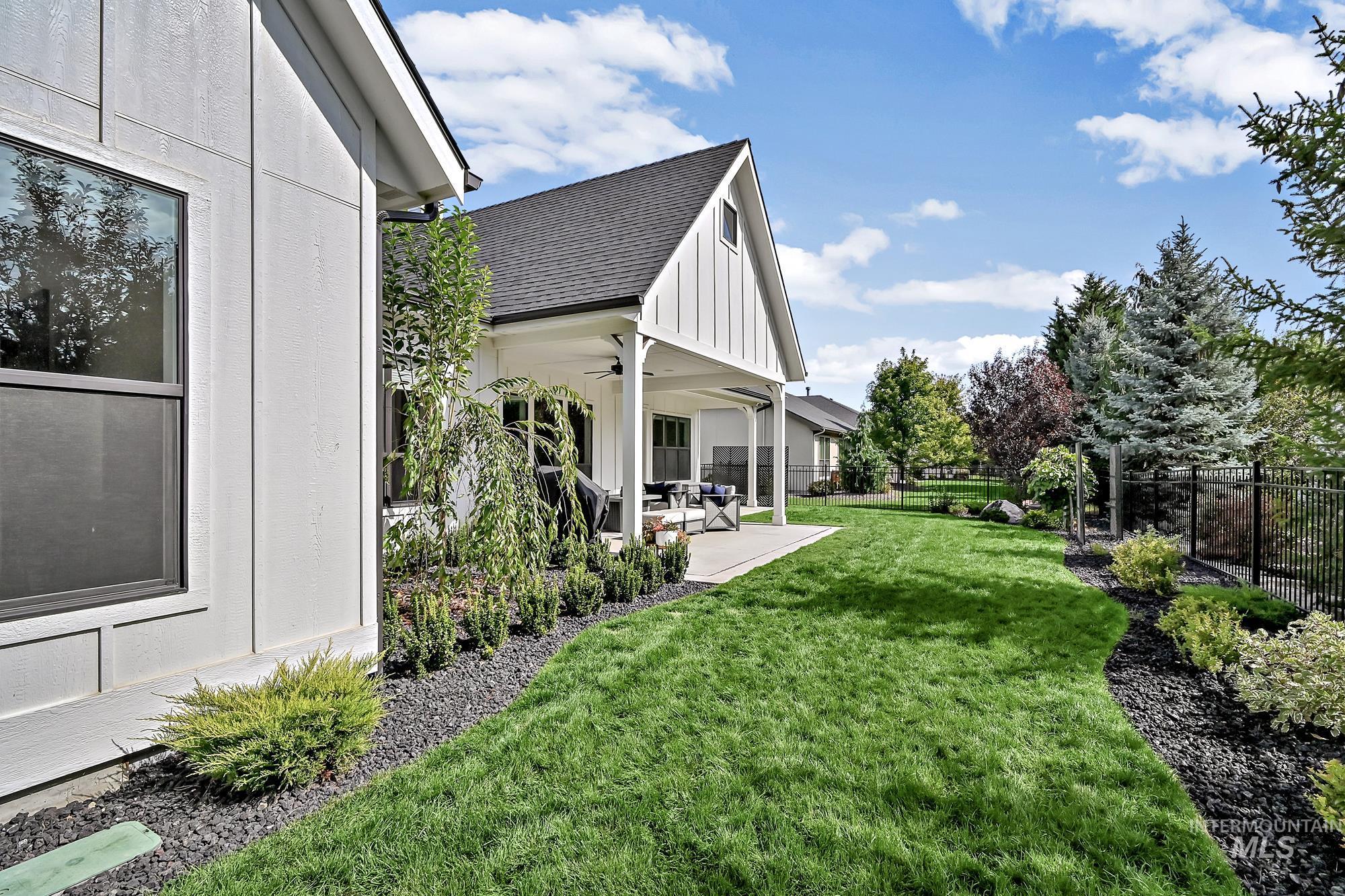 Fenced backyard featuring ceiling fan and a patio area