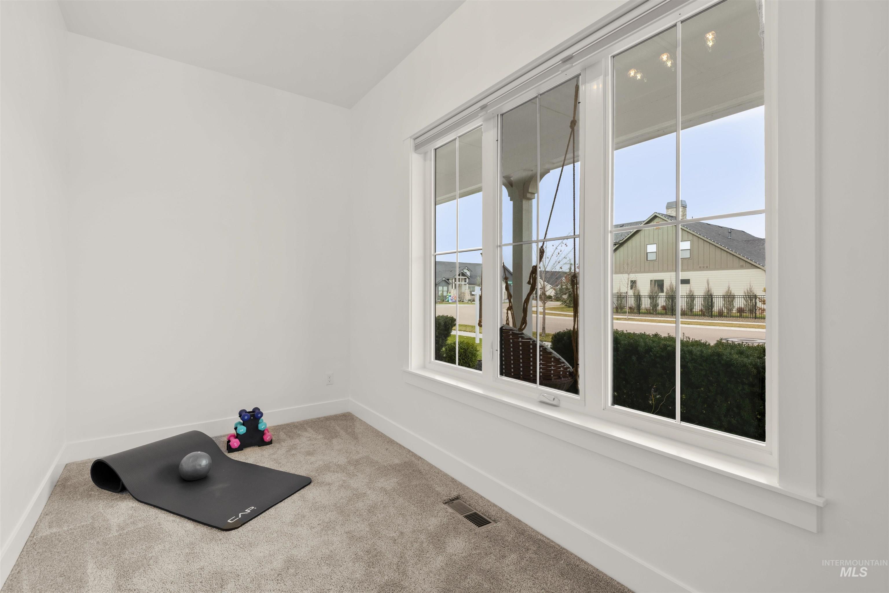 Workout area featuring baseboards and carpet floors