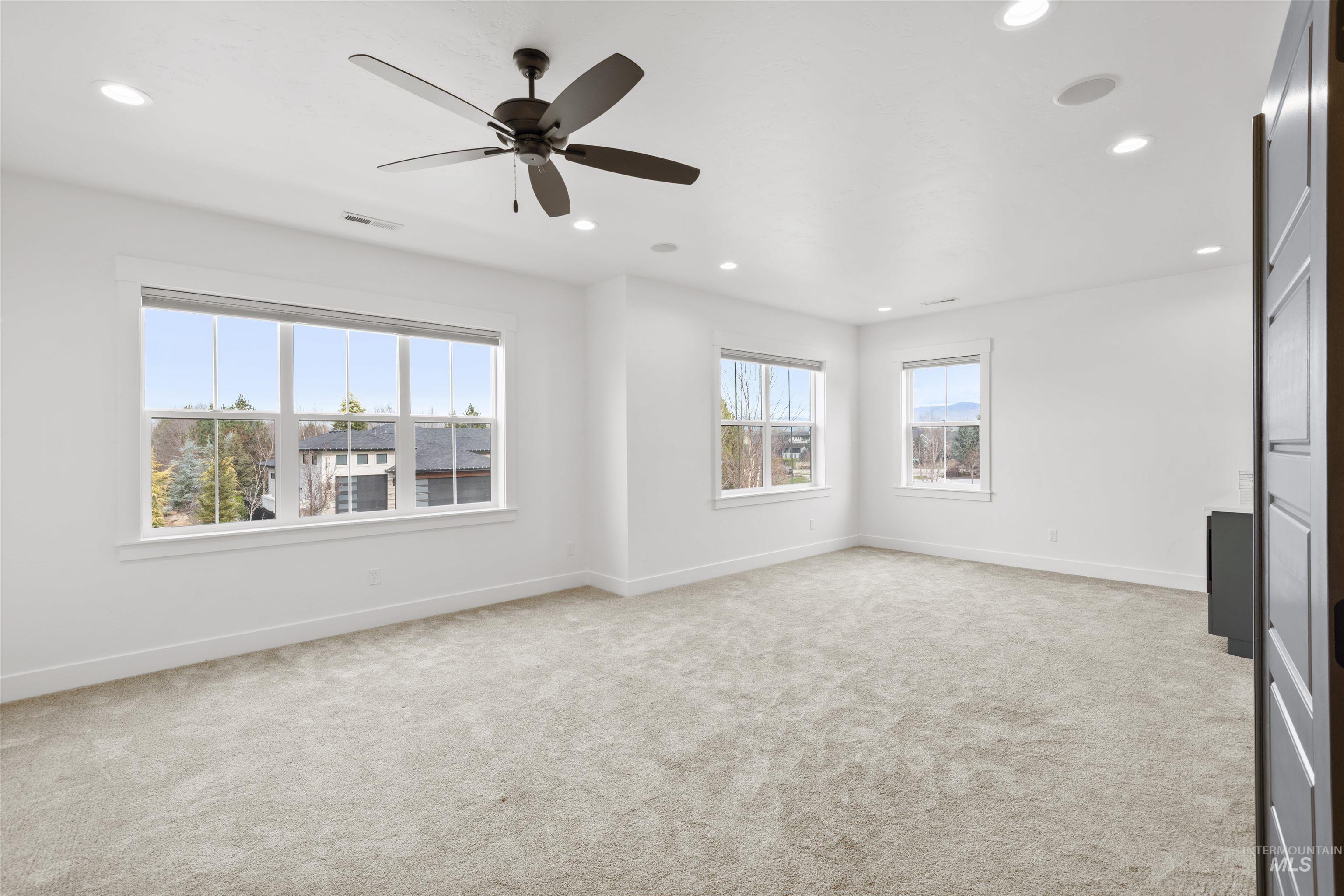 Unfurnished room with light colored carpet, ceiling fan, and recessed lighting