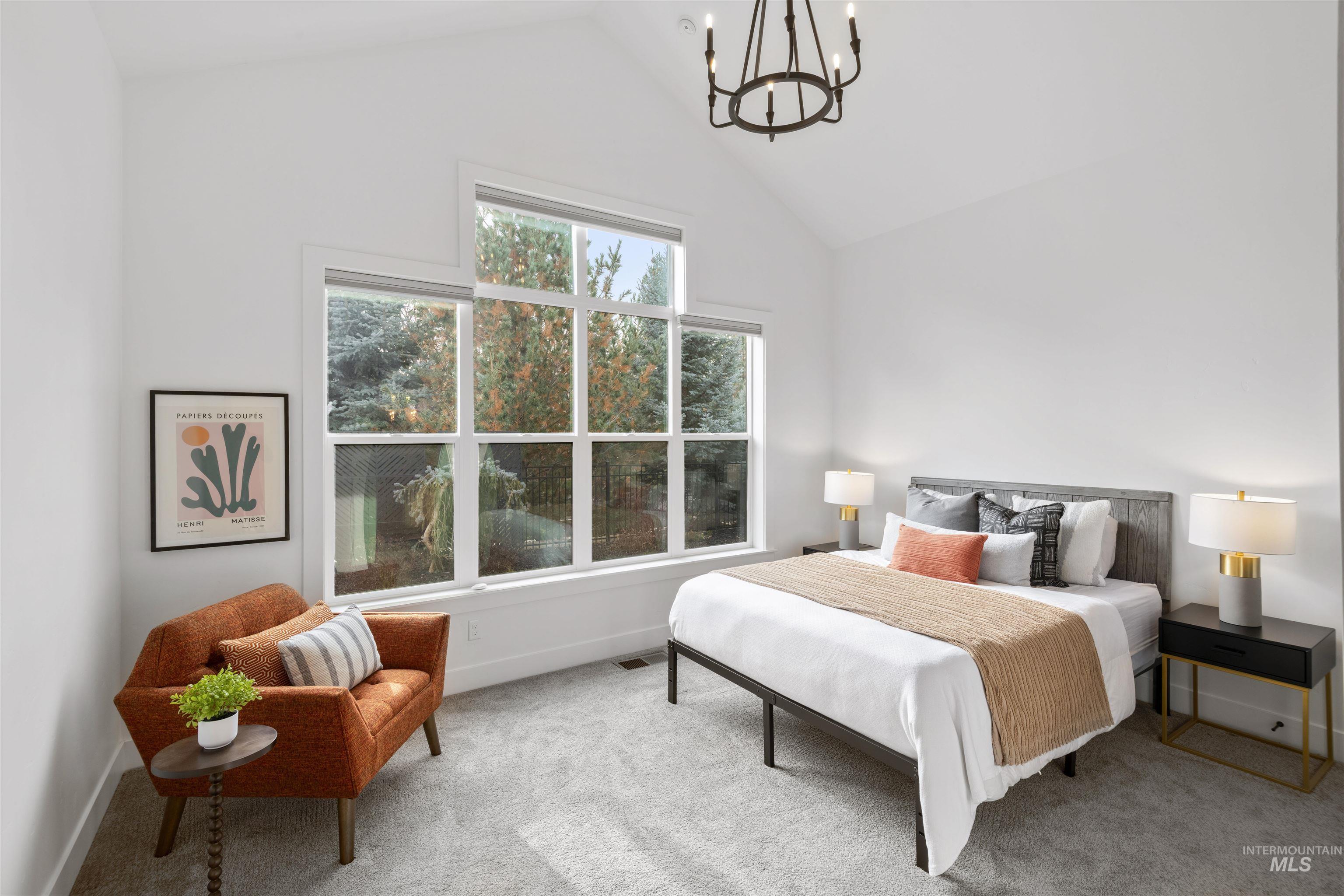 Bedroom with a chandelier, carpet floors, and high vaulted ceiling