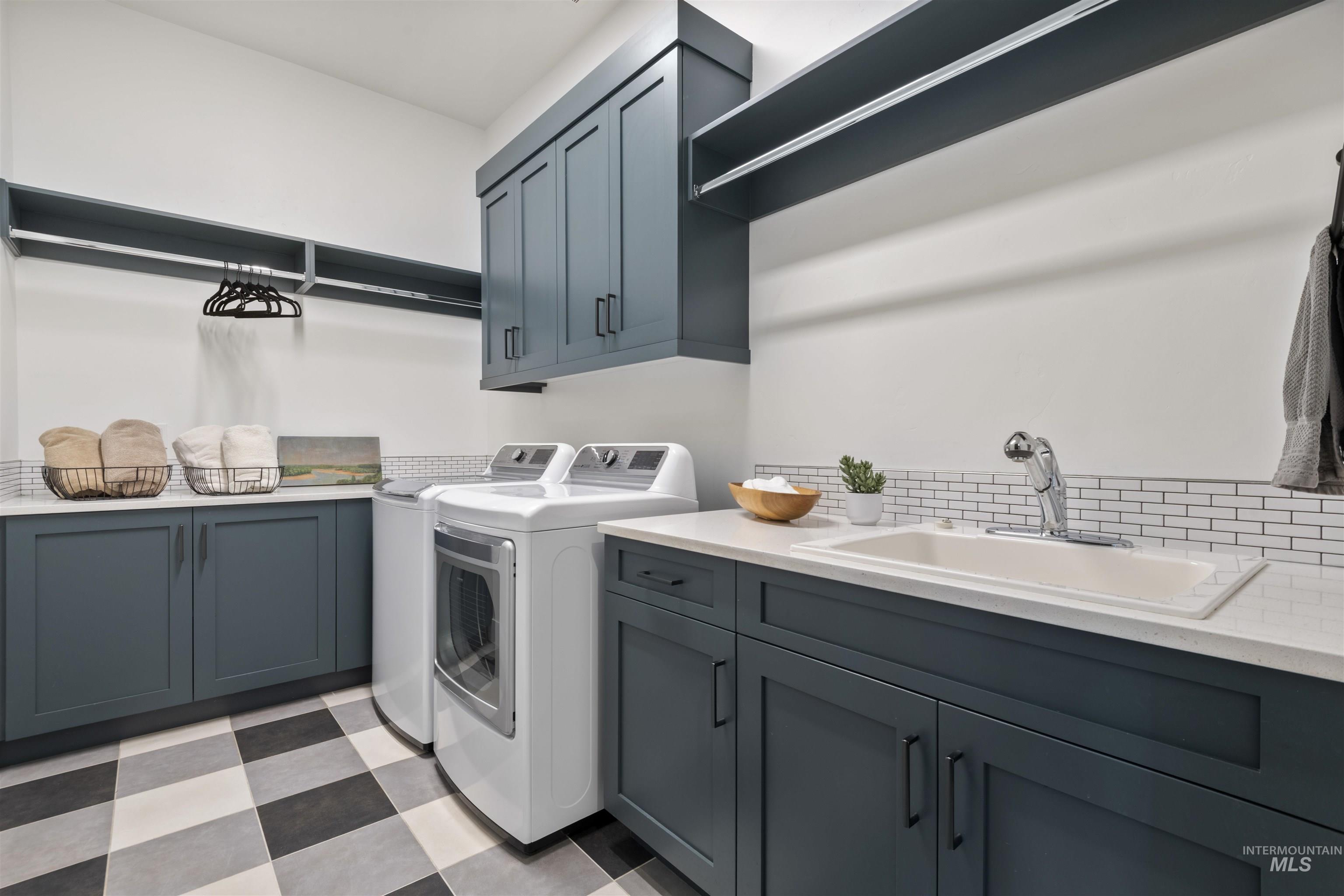 Laundry area with light flooring, washing machine and dryer, and cabinet space