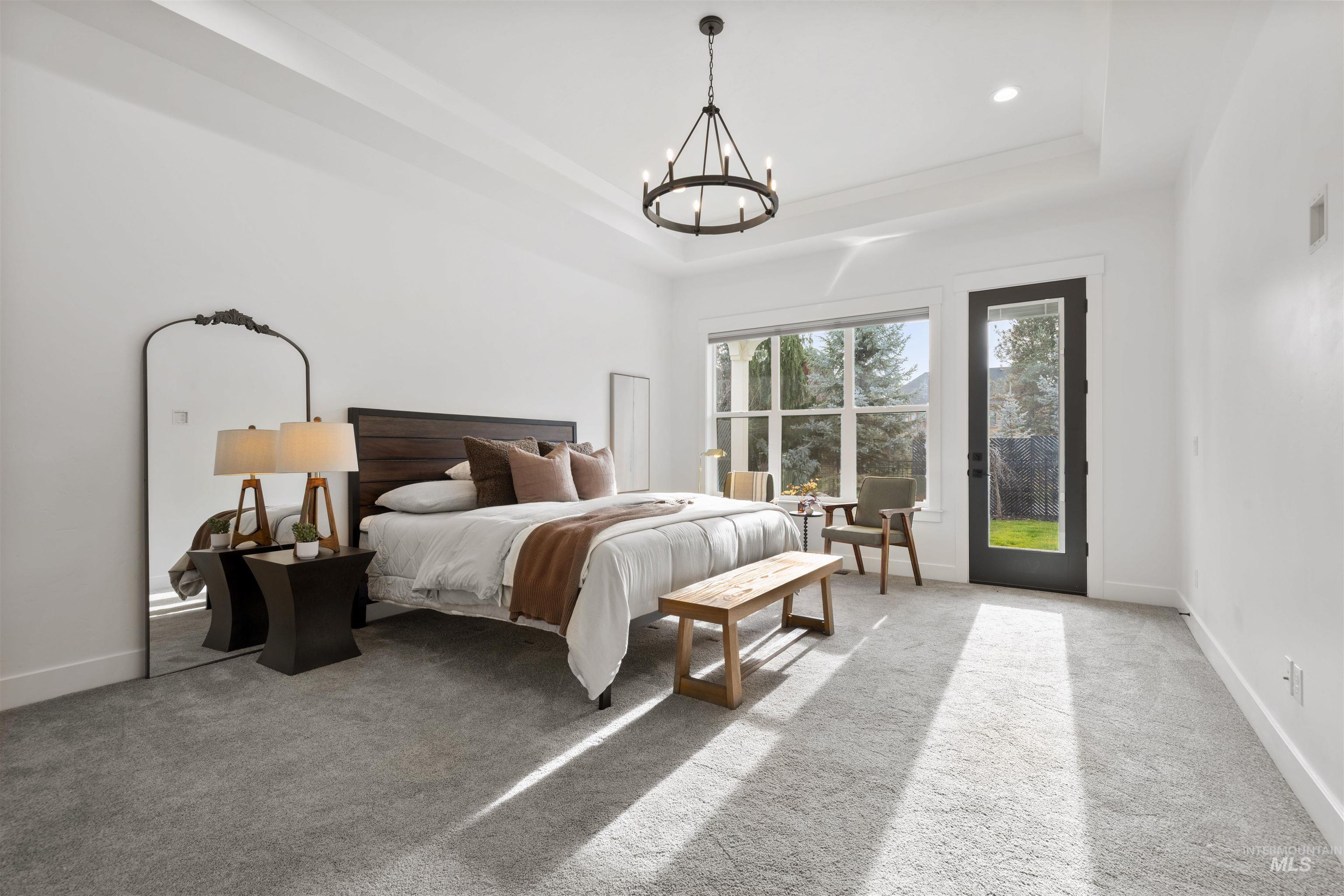 Bedroom with light colored carpet, access to outside, a chandelier, recessed lighting, and a tray ceiling