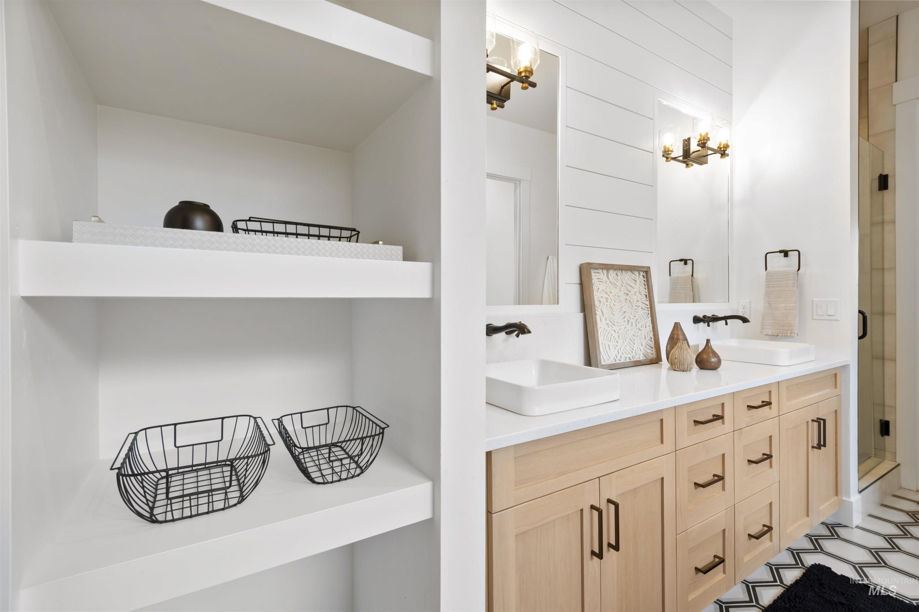 Full bathroom featuring double vanity and a stall shower