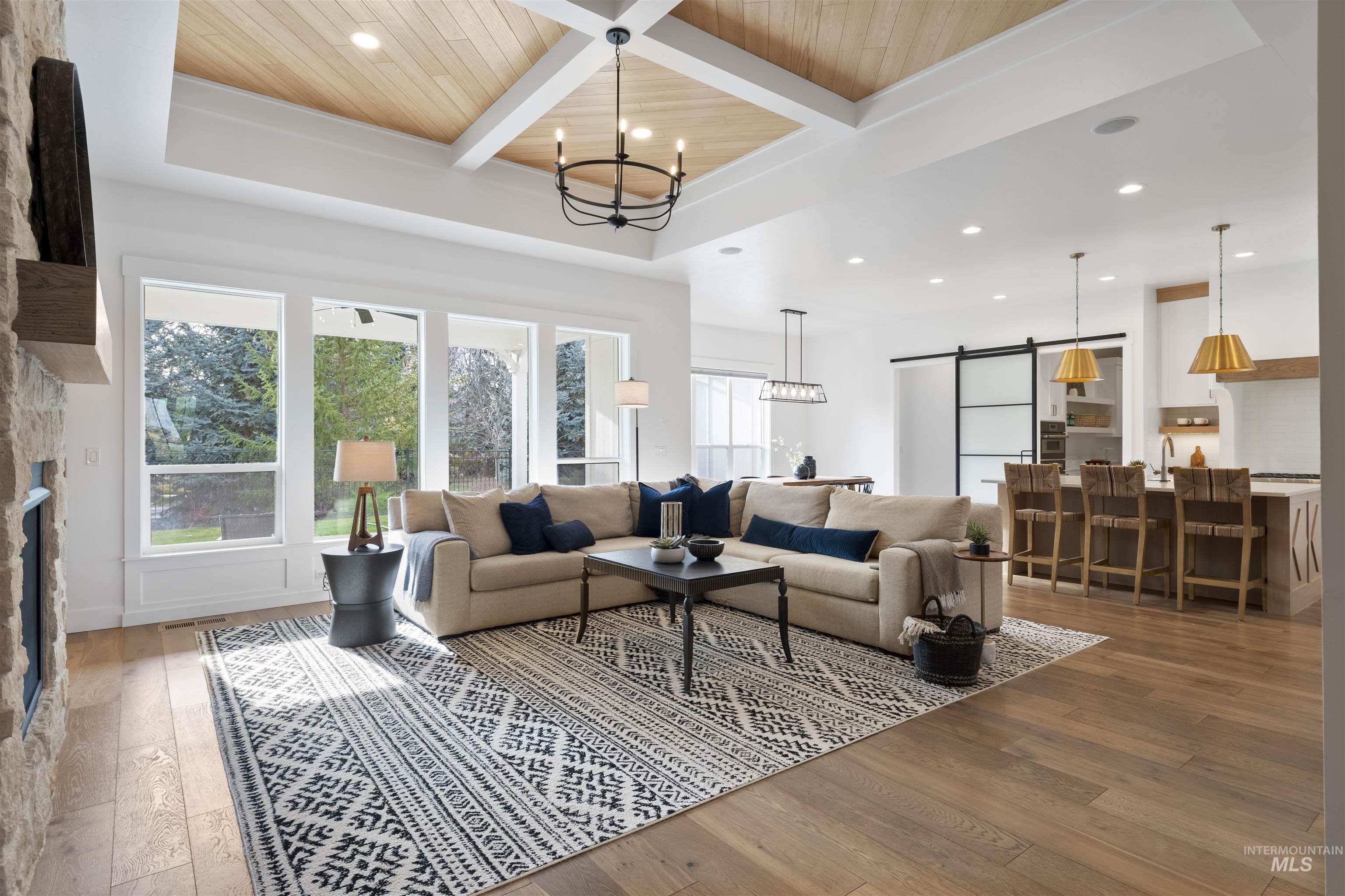 Living room featuring a barn door, a fireplace, recessed lighting, hardwood / wood-style flooring, and a chandelier