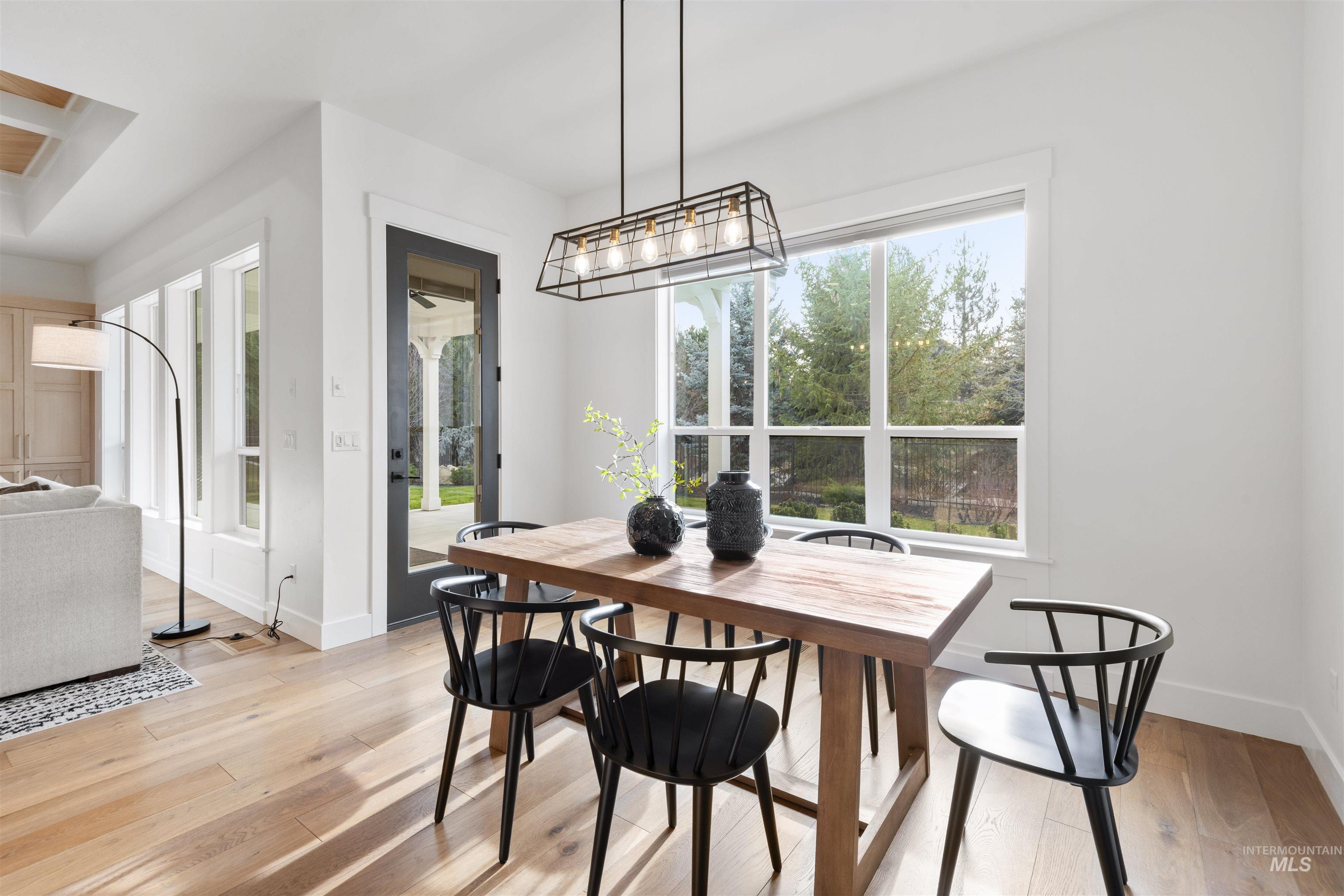 Dining room with light wood-style floors and healthy amount of natural light