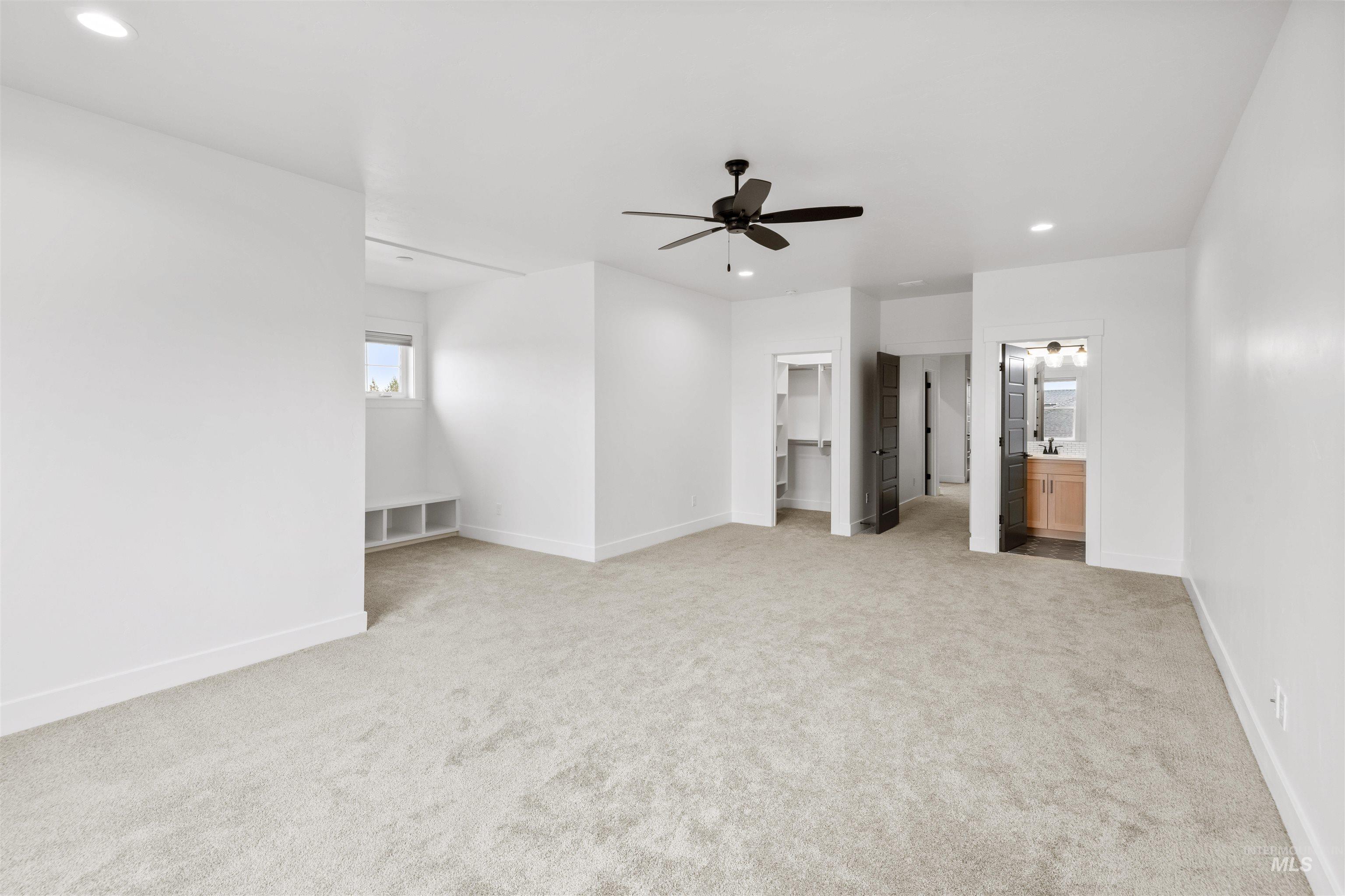 Unfurnished bedroom with recessed lighting, a spacious closet, light carpet, ceiling fan, and connected bathroom