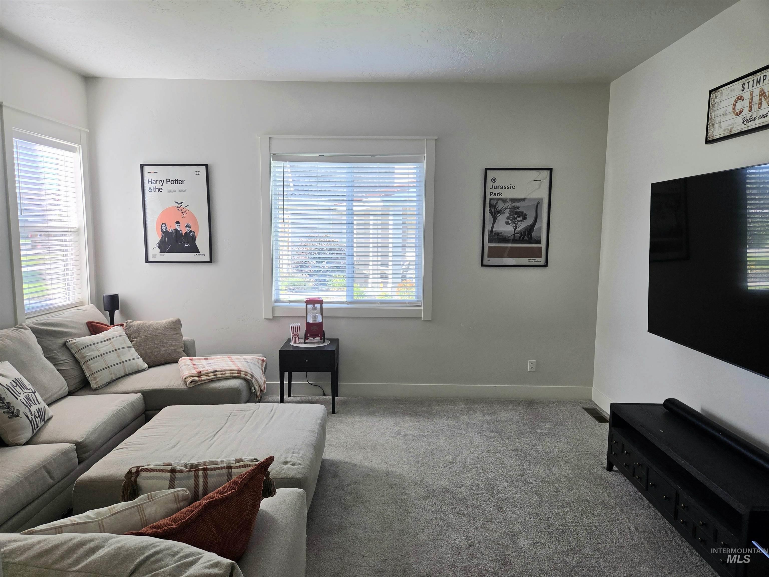 Carpeted living area featuring baseboards