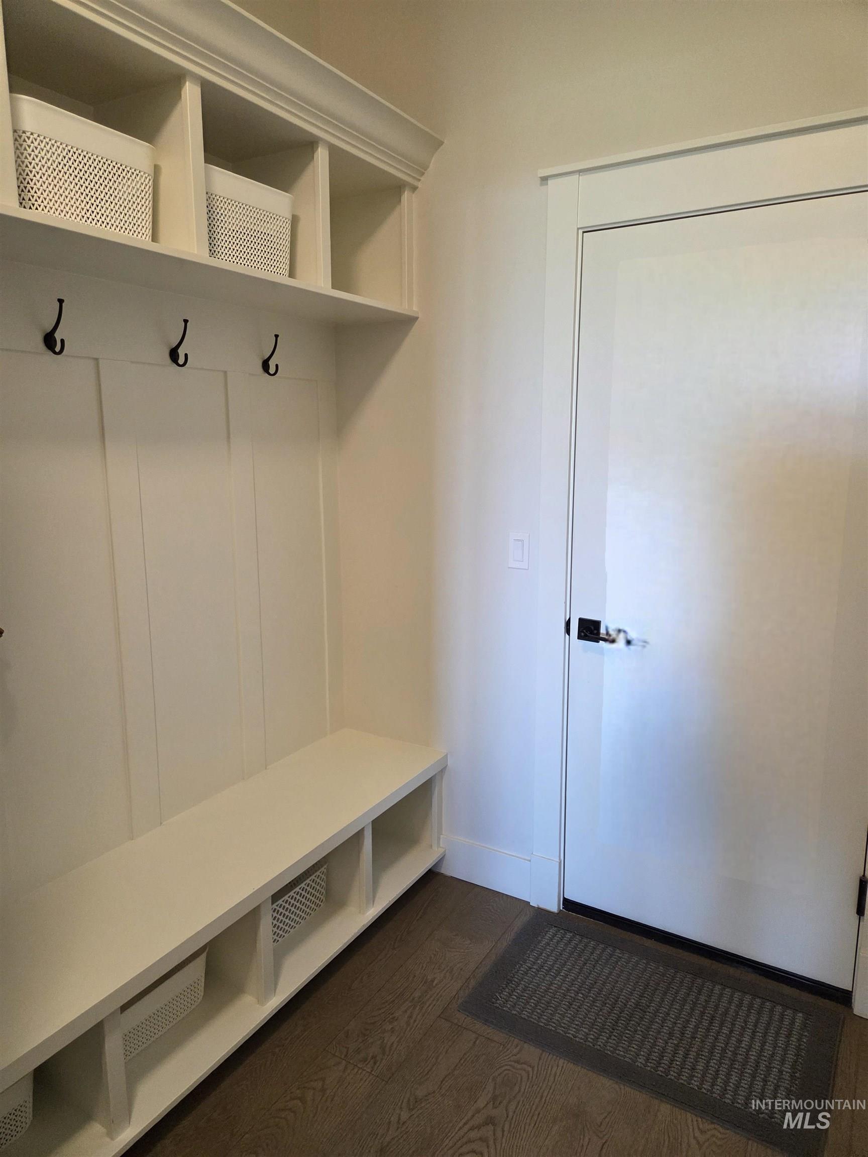 Mudroom featuring dark wood-style flooring and baseboards