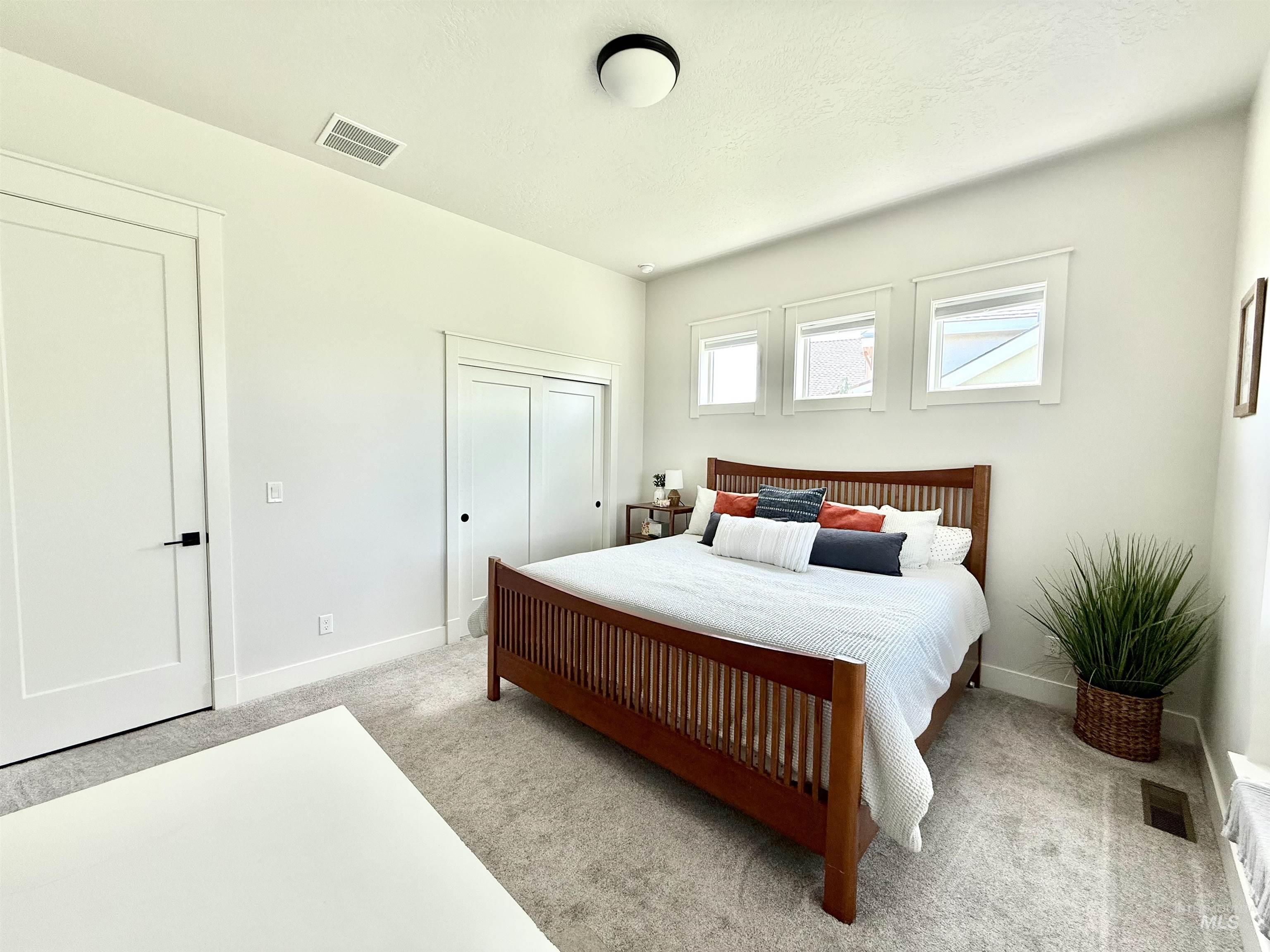 Bedroom featuring light colored carpet and a closet