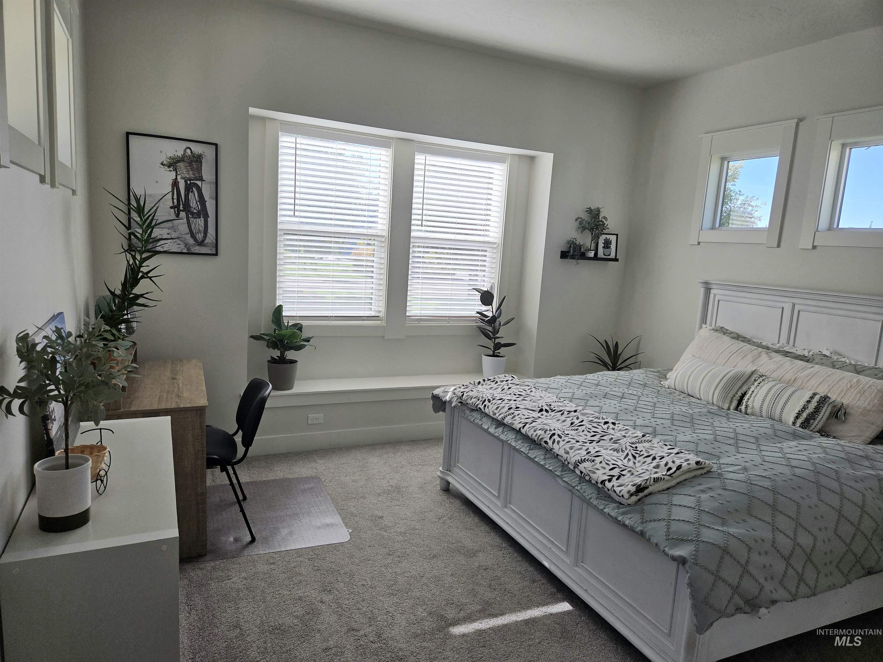 Bedroom with light colored carpet and baseboards