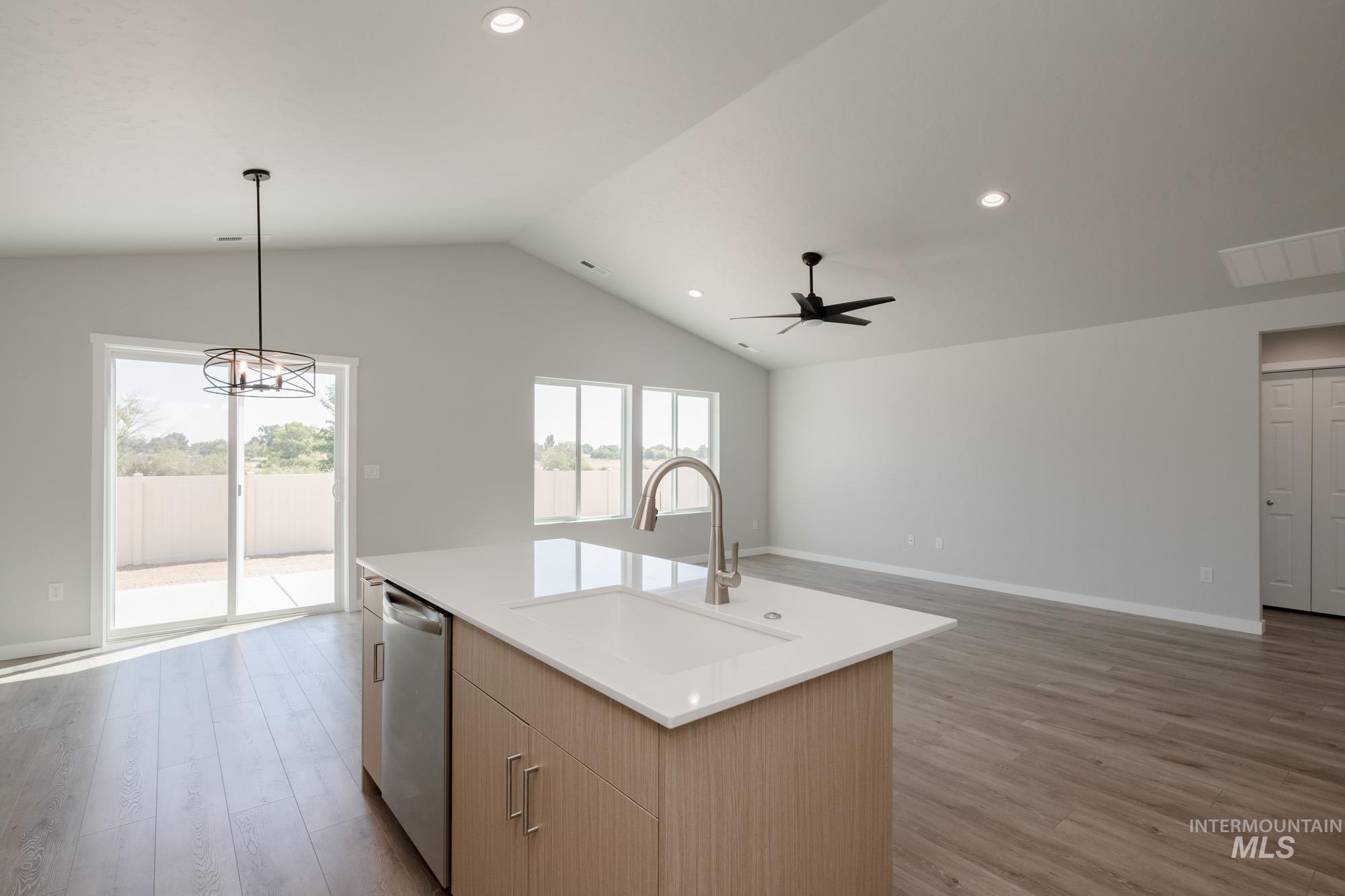 Kitchen with pendant lighting, light wood finished floors, open floor plan, recessed lighting, and vaulted ceiling