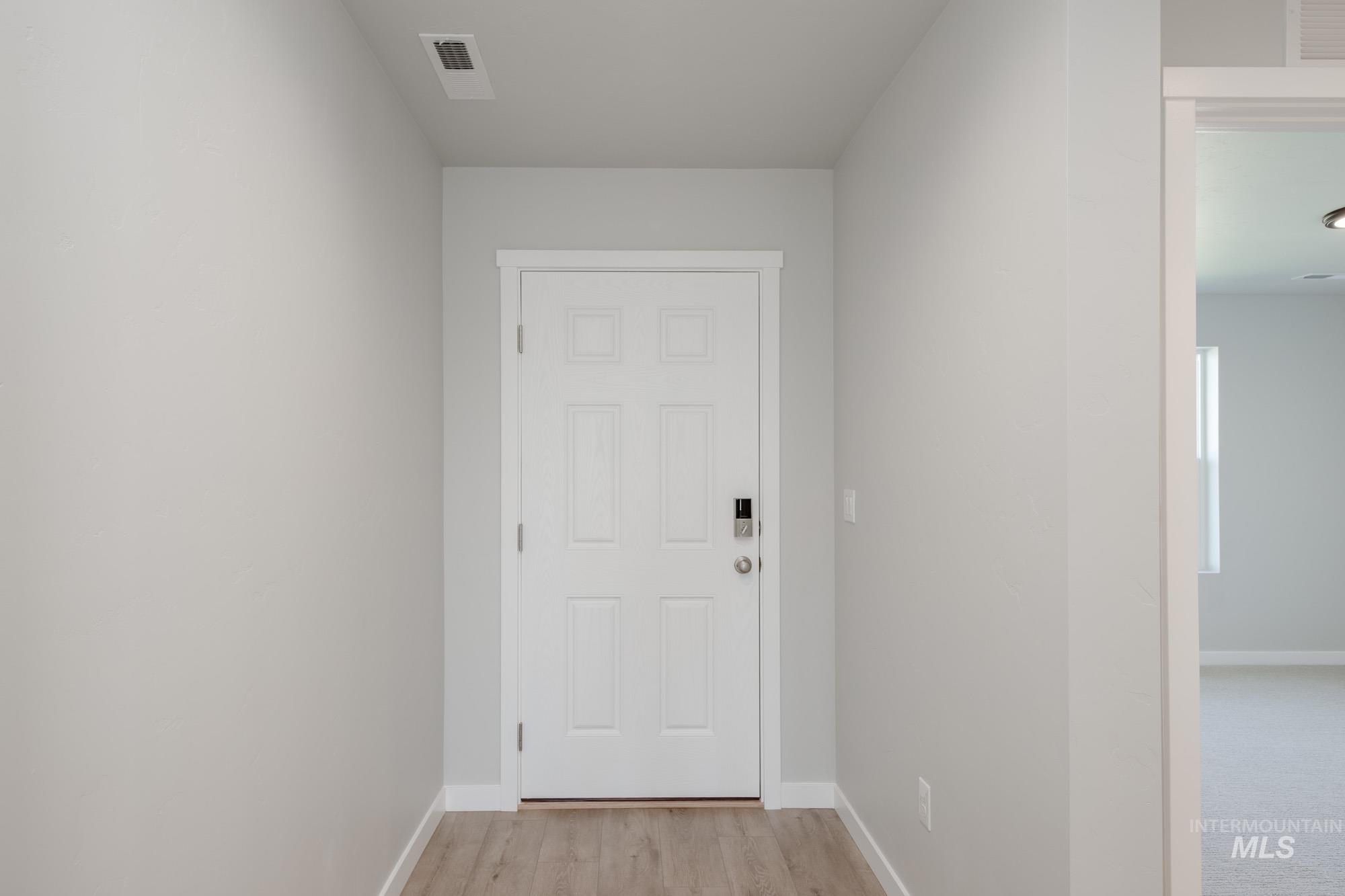 Doorway to outside featuring baseboards and wood finished floors