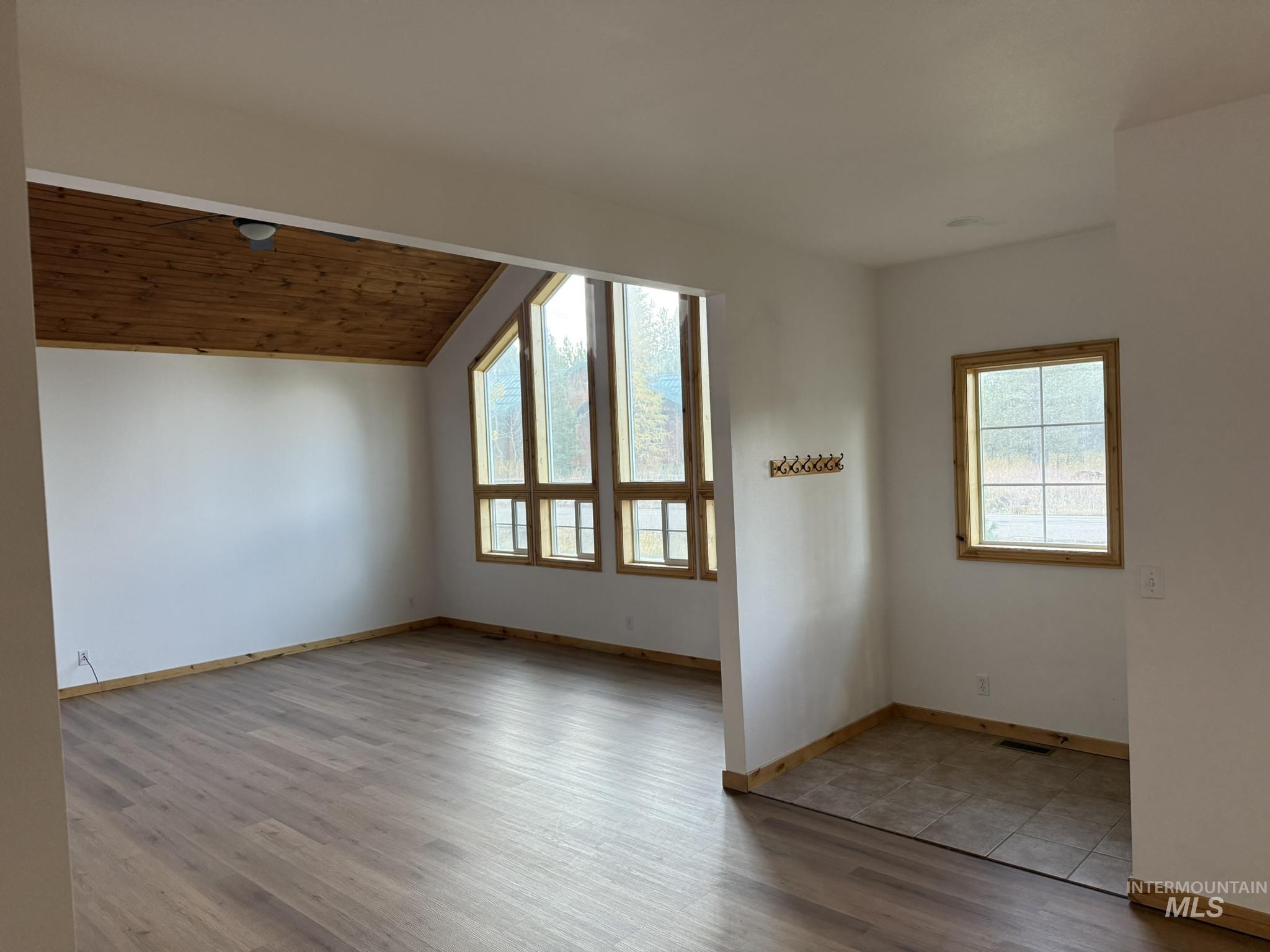 Spare room with light wood-style floors, wooden ceiling, and vaulted ceiling