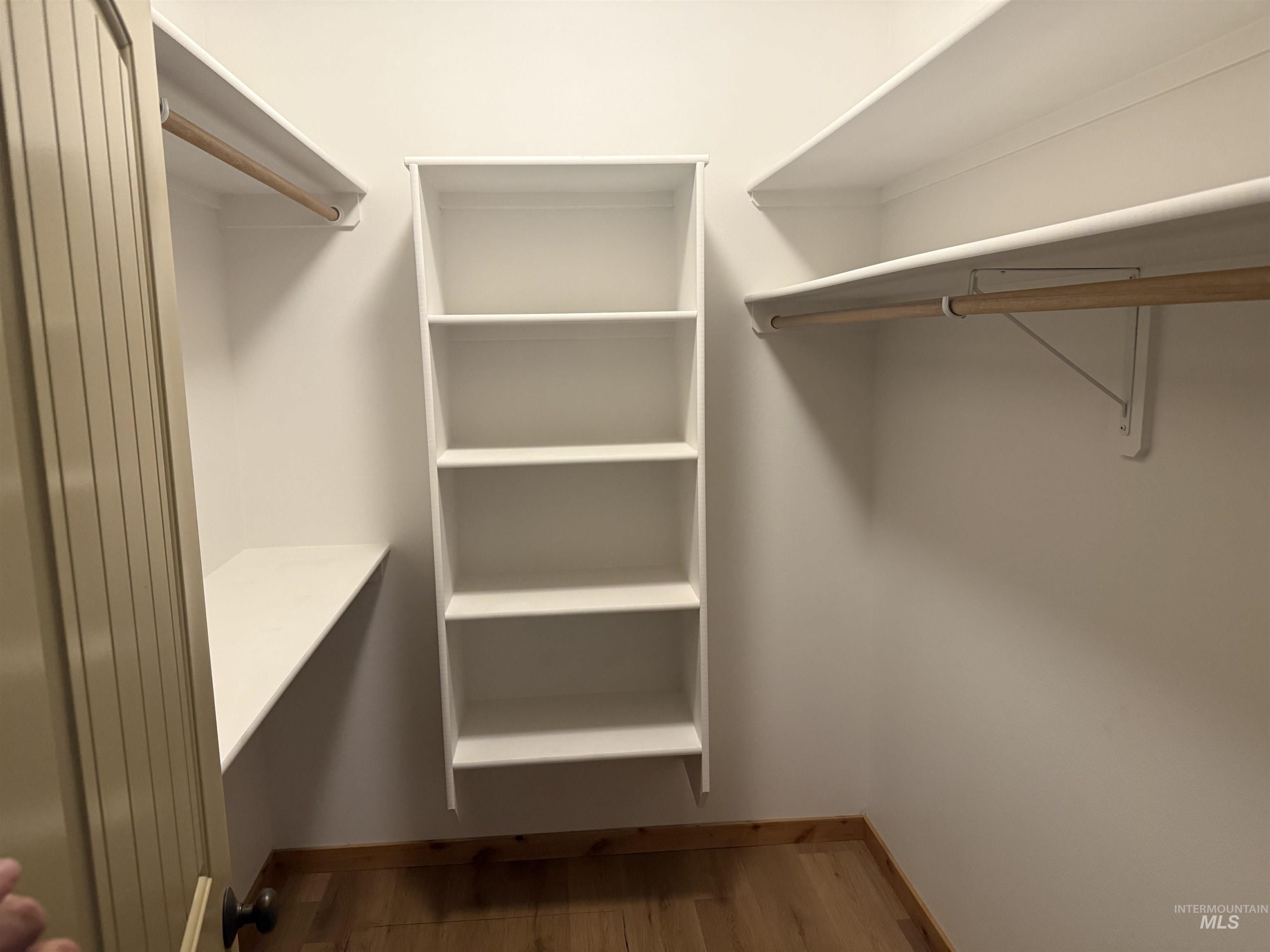 Spacious closet featuring dark wood finished floors