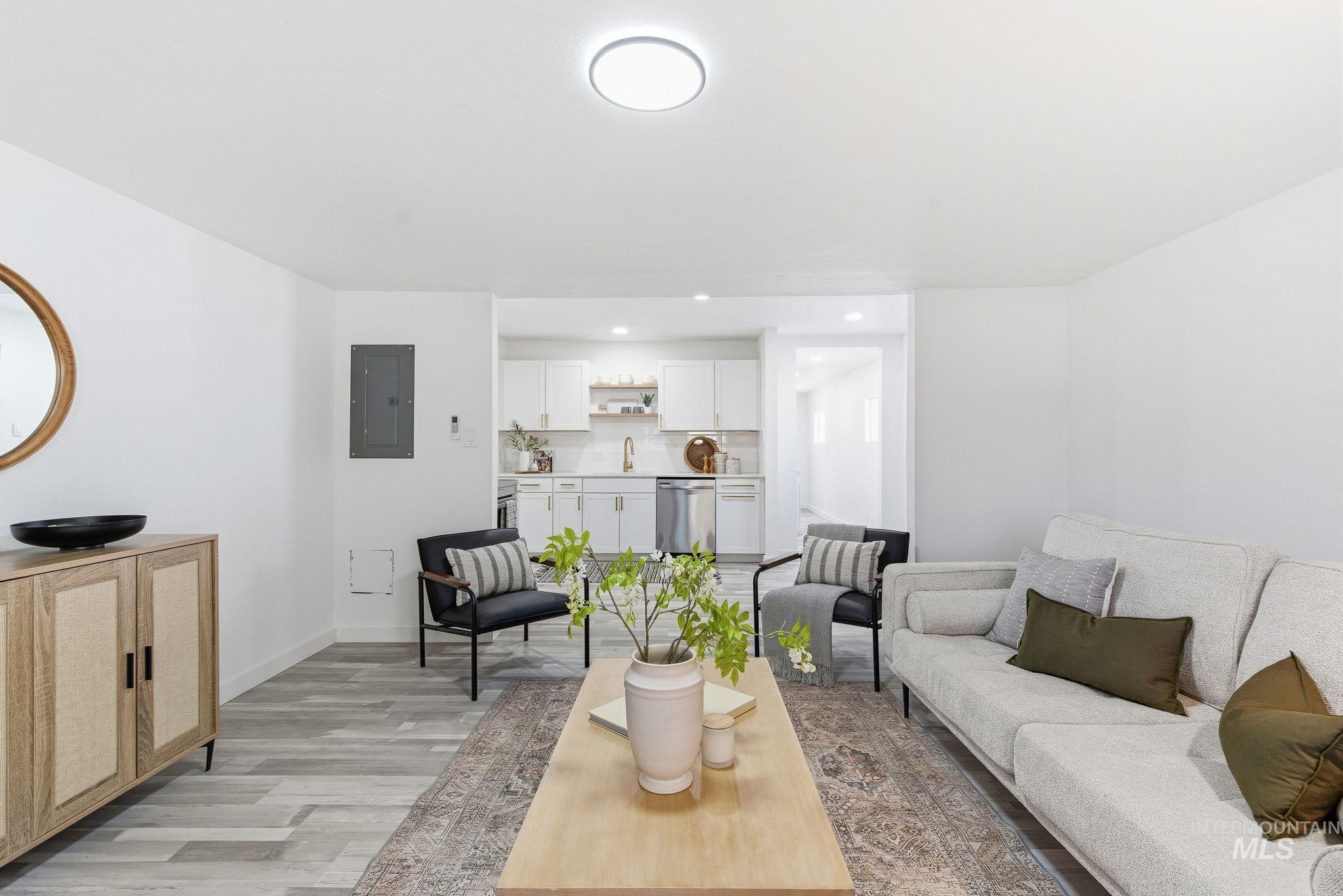Living room featuring light wood-style floors, electric panel, and recessed lighting