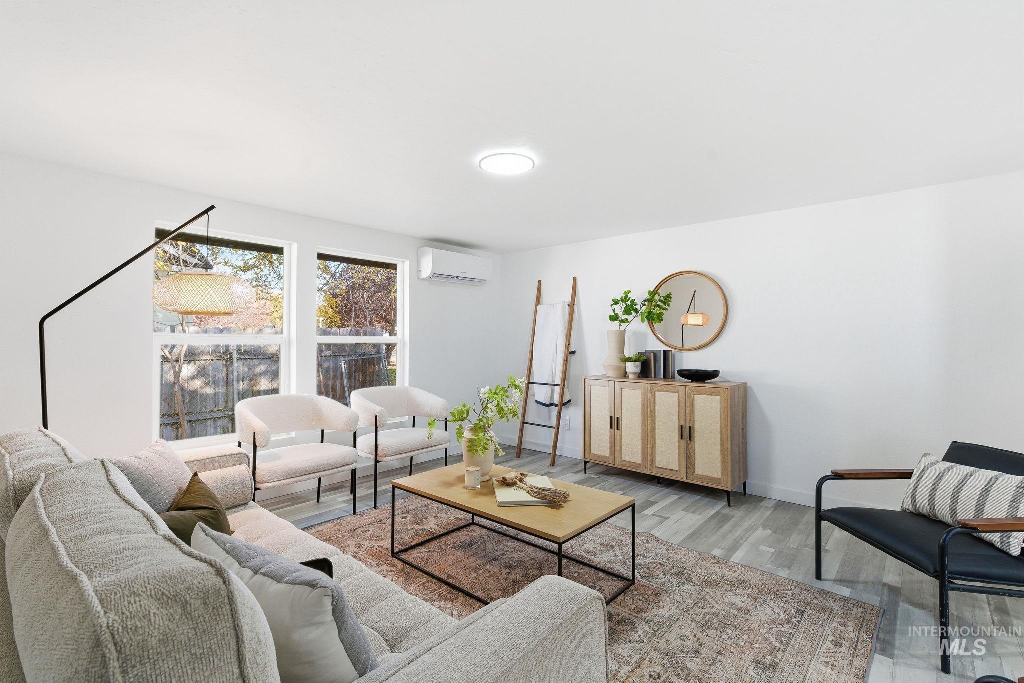 Living area with light wood-type flooring and a wall unit AC