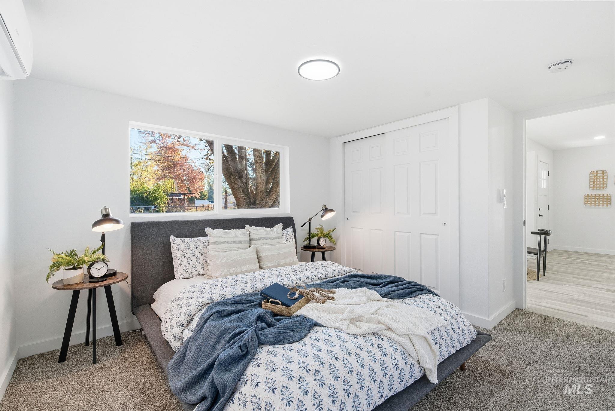 Bedroom featuring a wall unit AC, a closet, and carpet