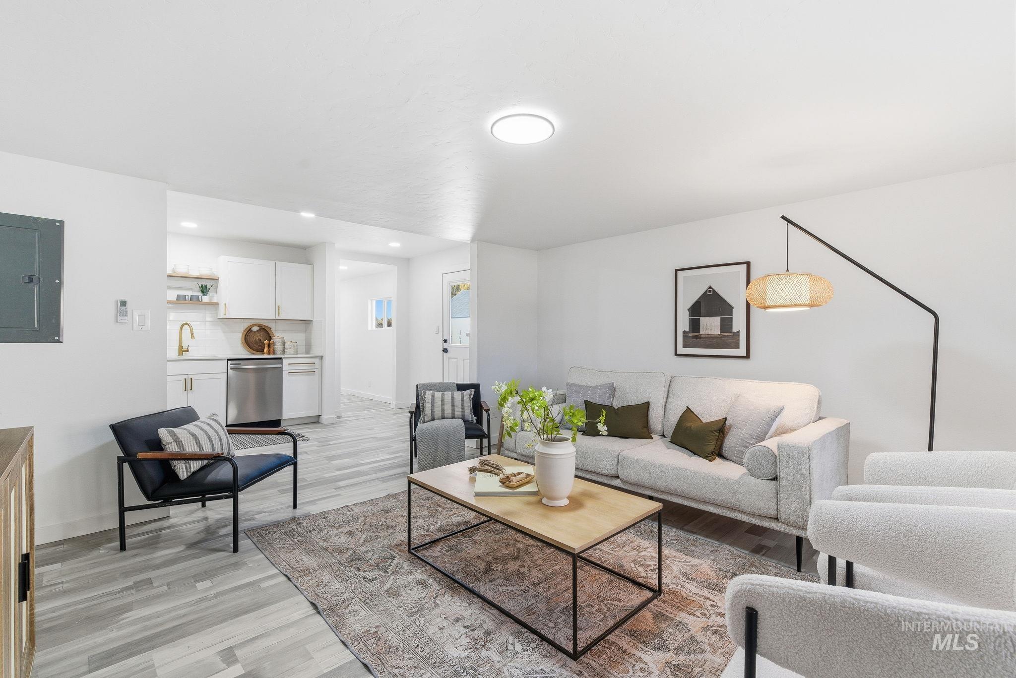 Living area featuring light wood finished floors, electric panel, and recessed lighting