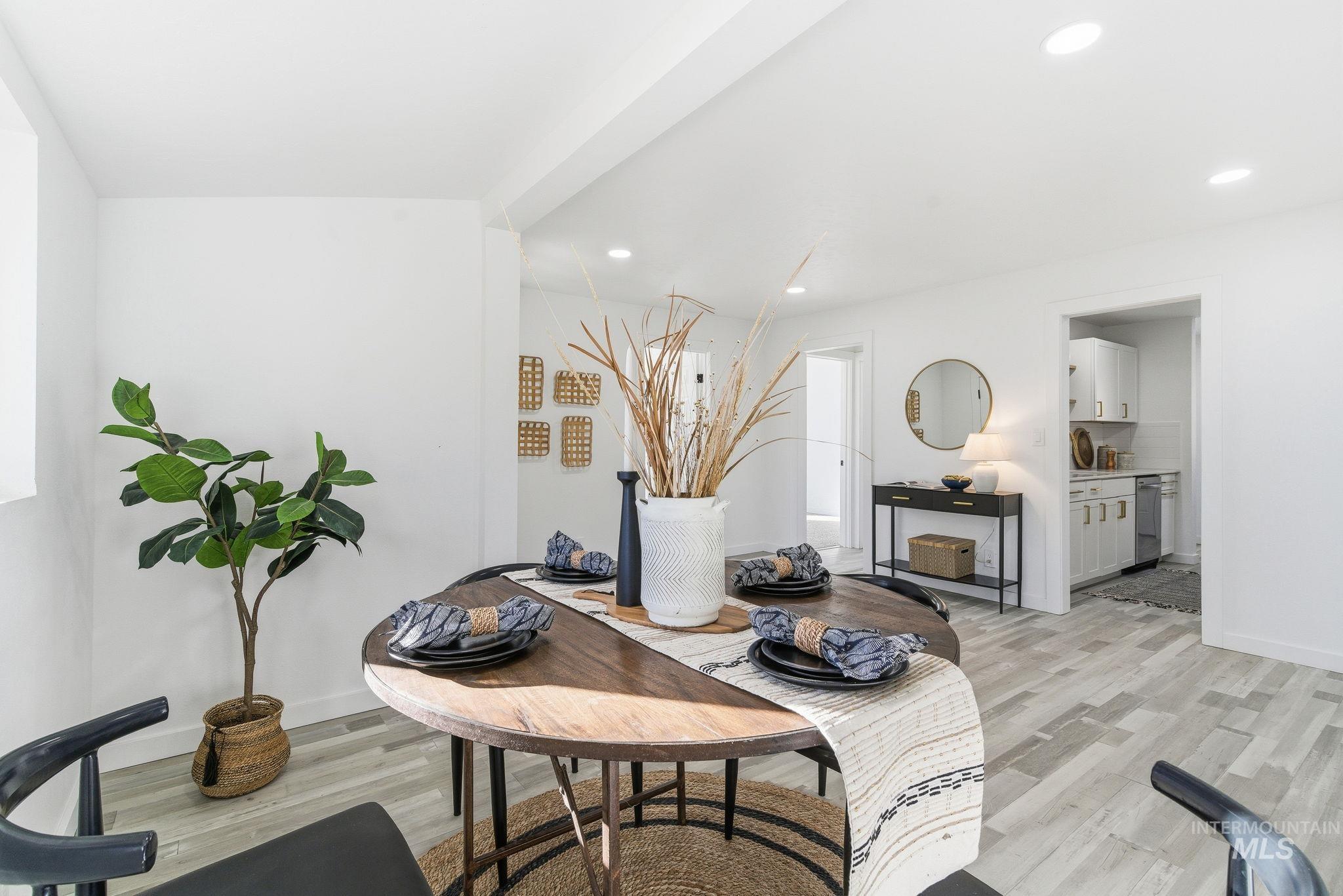 Dining room with light wood finished floors and recessed lighting