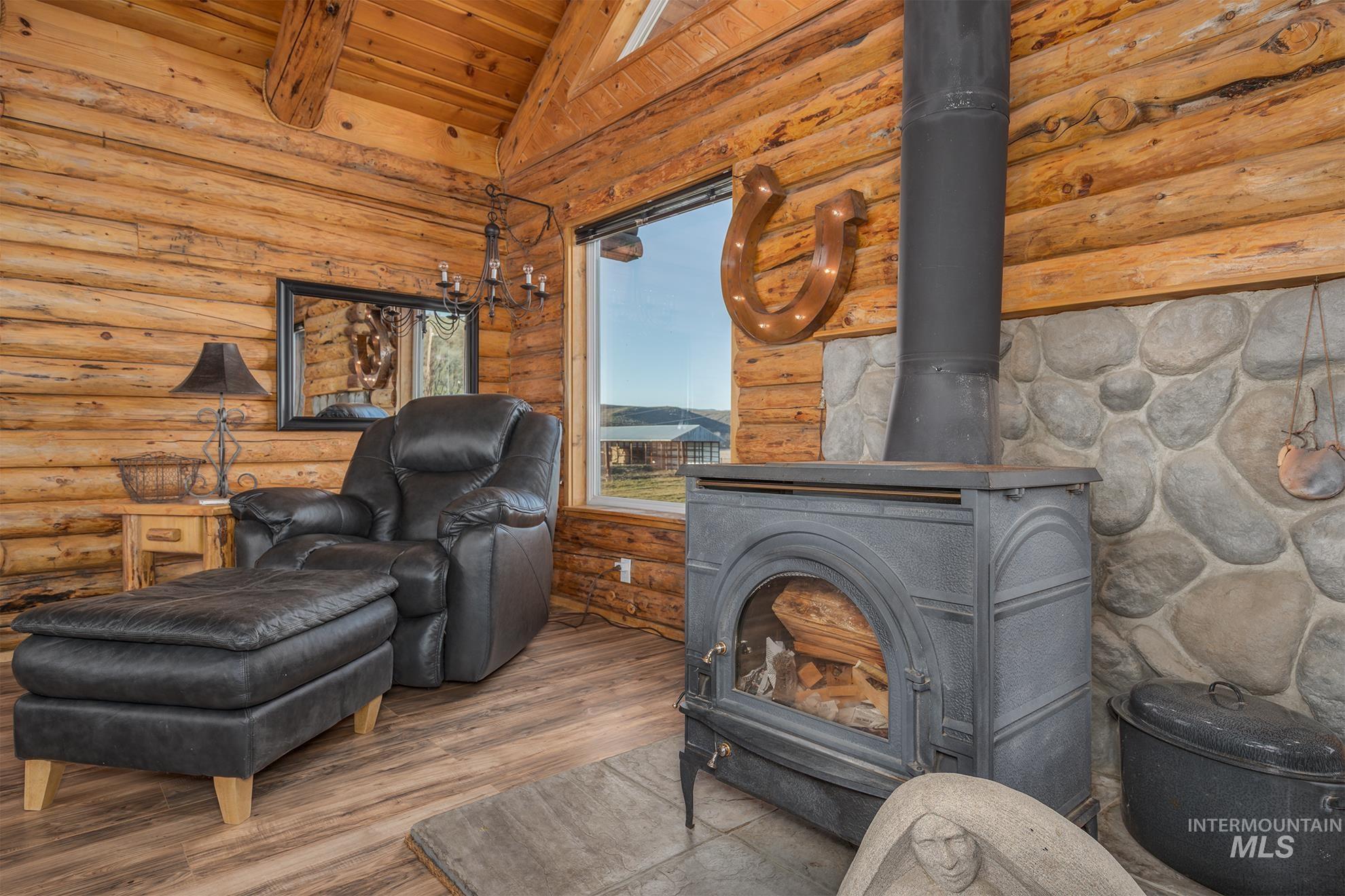 Detailed view of a wood stove, wood finished floors, and a wood ceiling with exposed beams