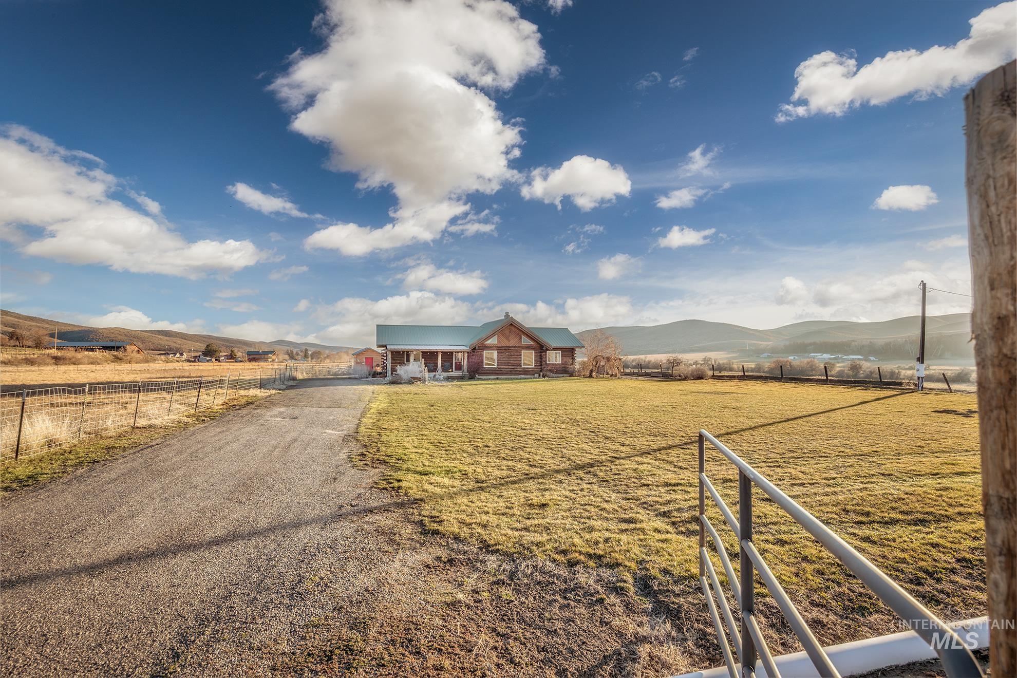 View of front of home with a mountain view, a view of countryside, and a metal roof