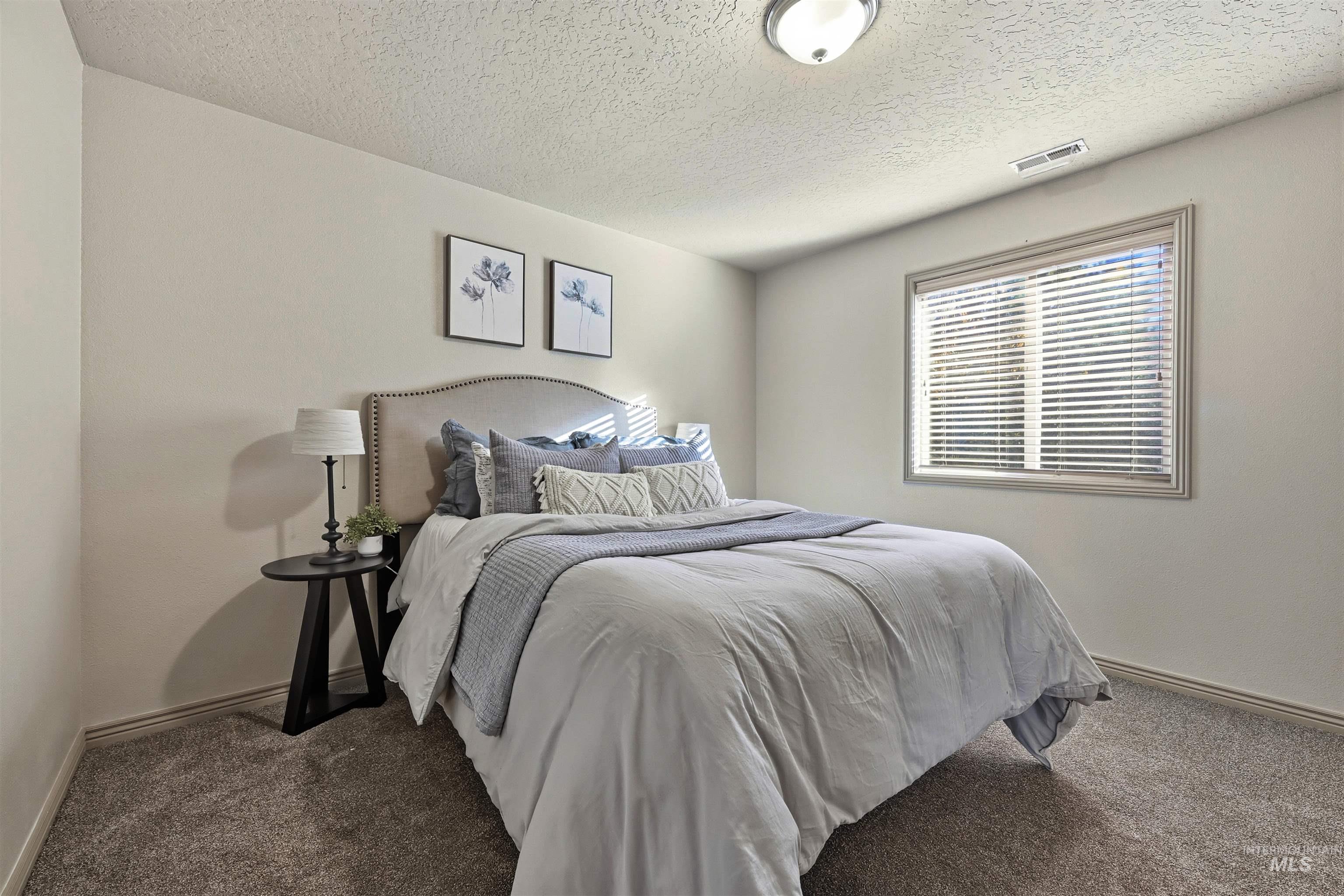 Bedroom featuring carpet and a textured ceiling