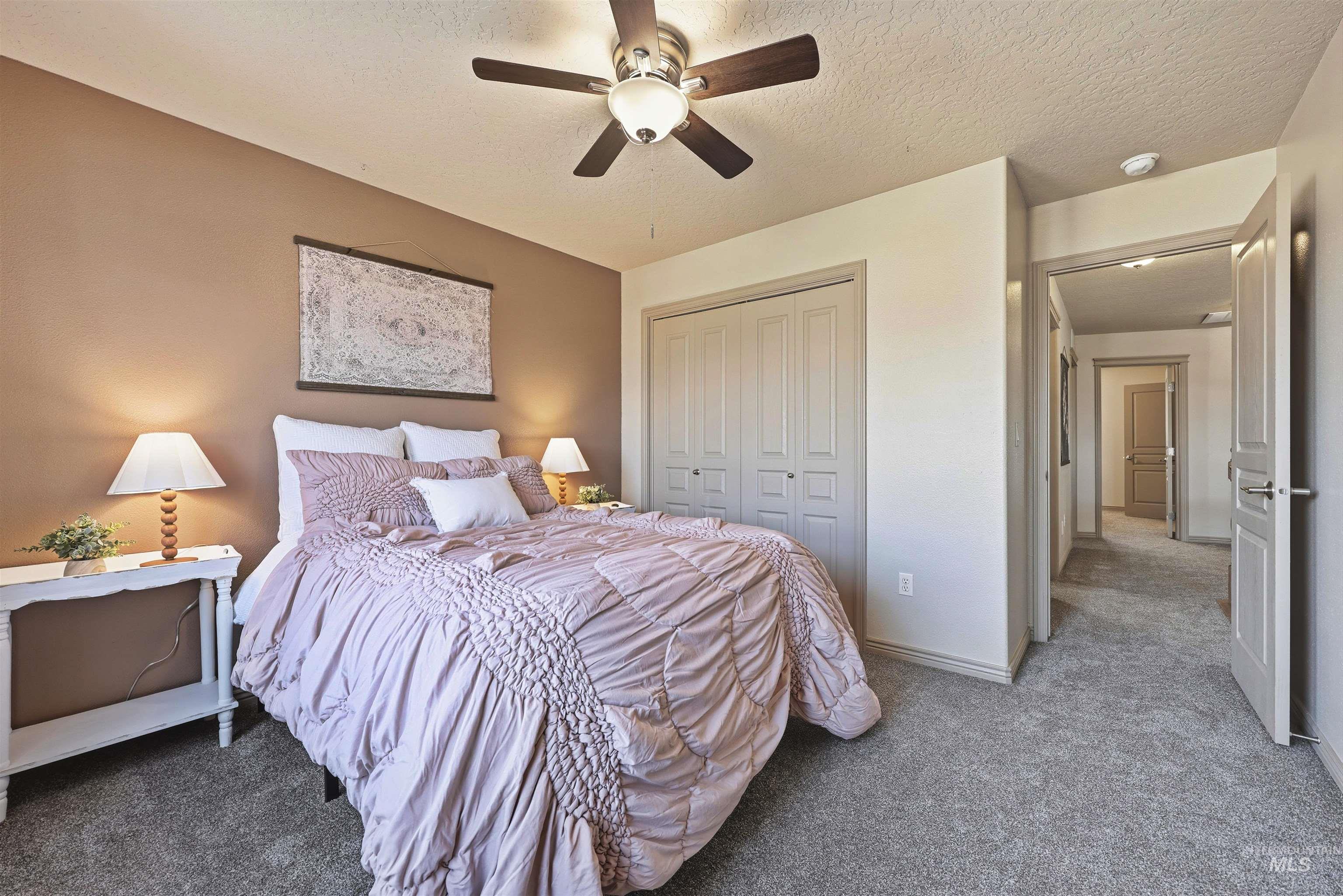 Bedroom featuring carpet floors, ceiling fan, a textured ceiling, and a closet