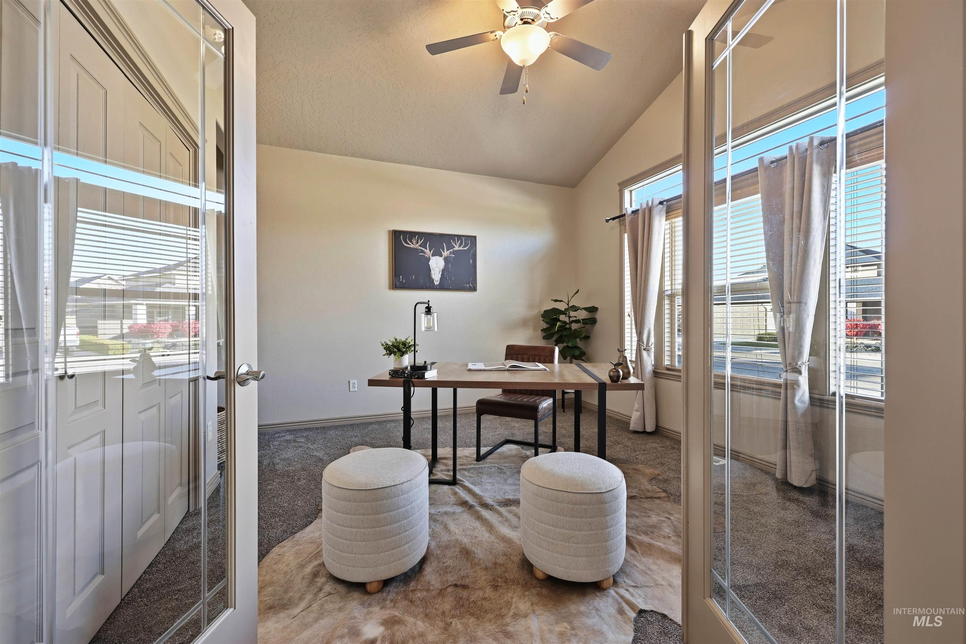 Office area with vaulted ceiling, carpet floors, and a ceiling fan