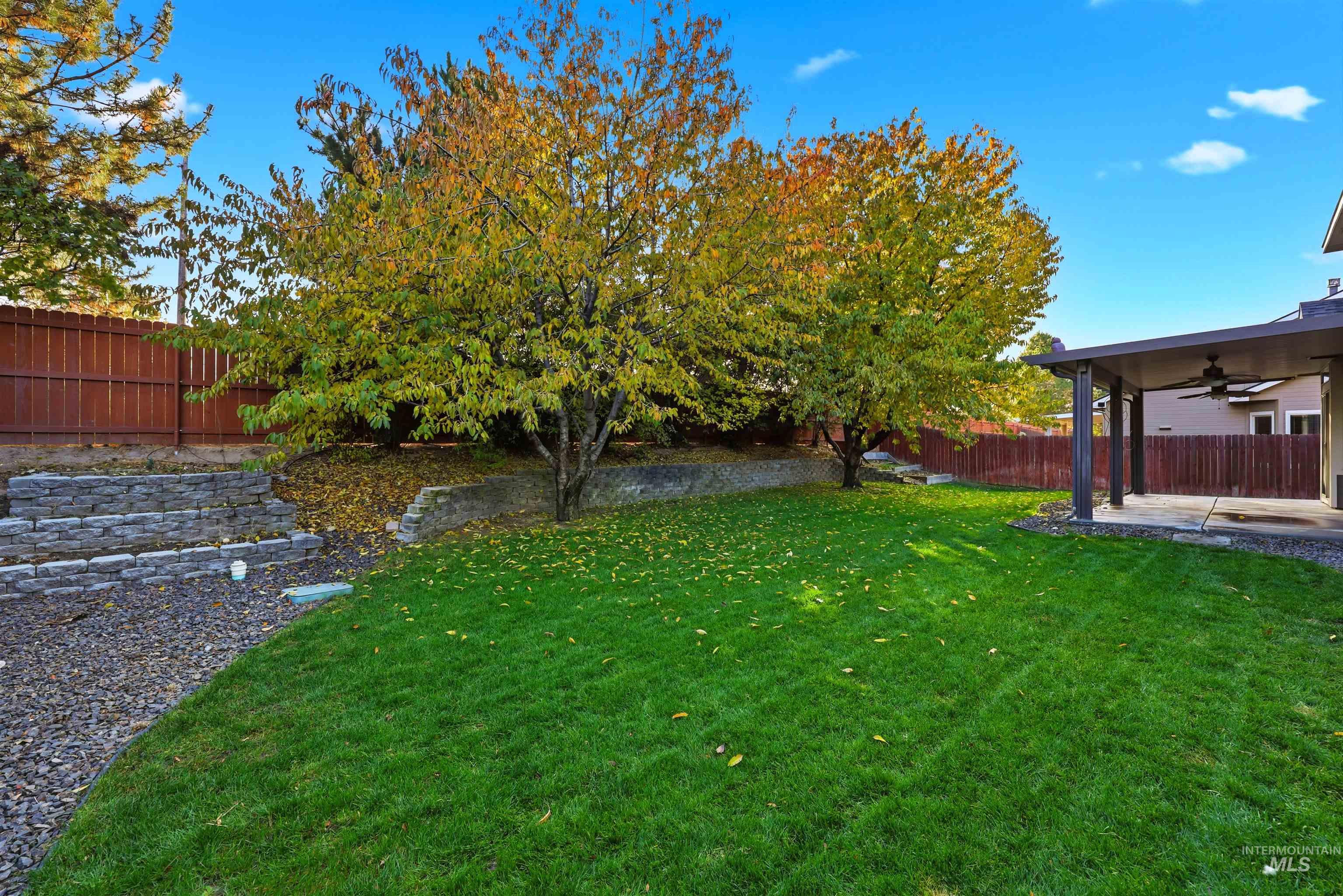 Fenced backyard featuring ceiling fan and a patio