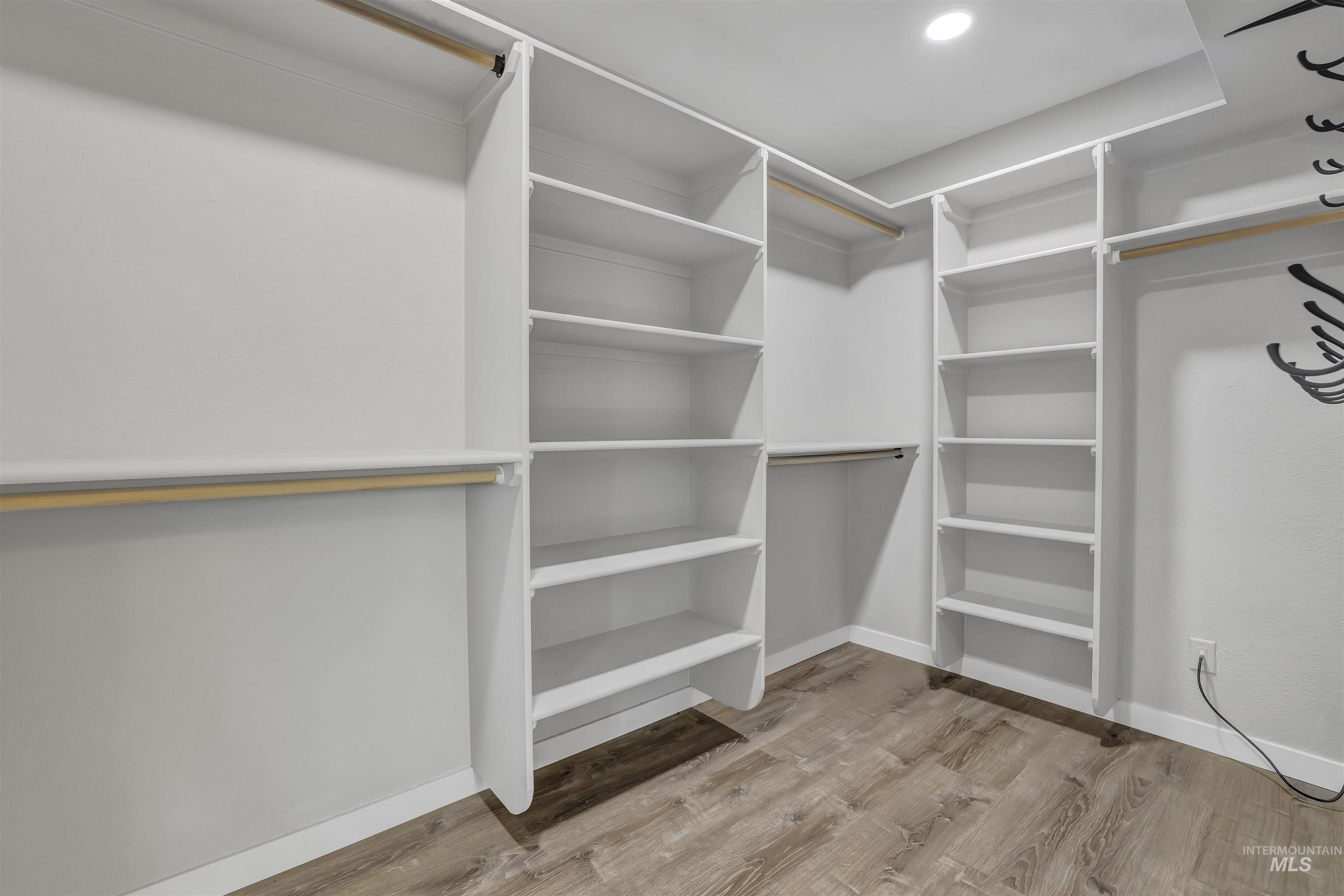 Spacious closet featuring light wood-style flooring
