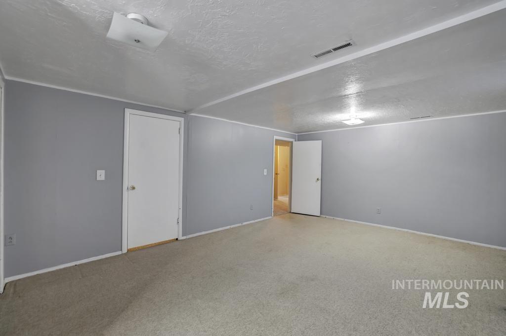Spare room with a textured ceiling and carpet flooring