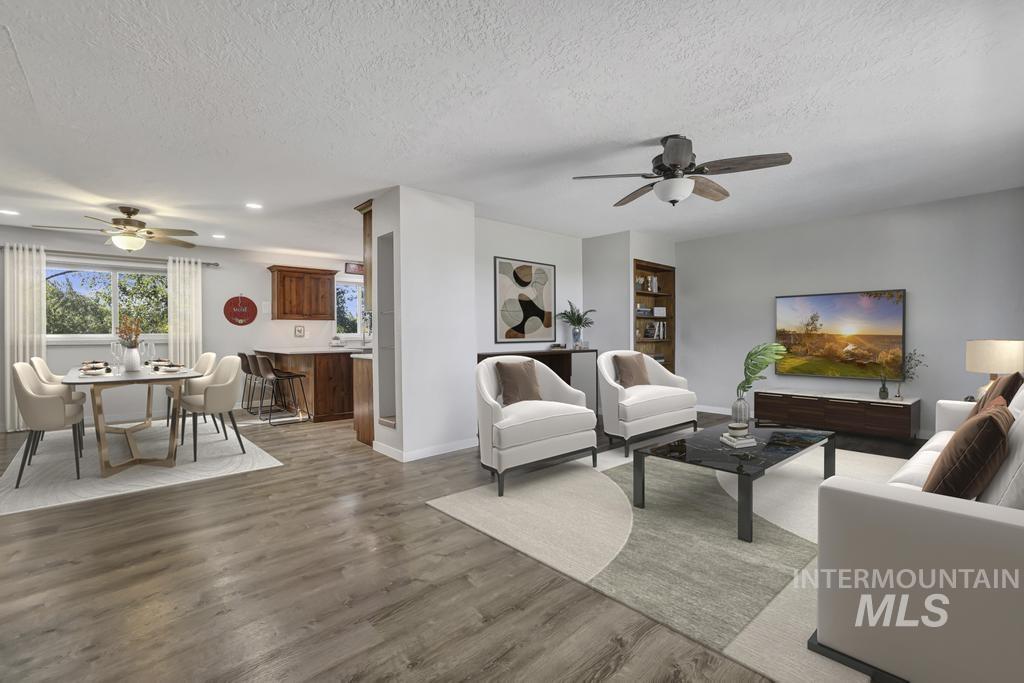 Living area with ceiling fan, a textured ceiling, and wood finished floors